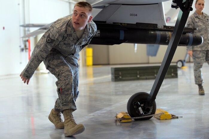 CREECH AIR FORCE BASE, Nev. --   Staff Sgt. William Bovee walks under the tail of an MQ-1B Predator while conducting post load checks during the 432d Aircraft Maintenance Squadron load crew of the quarter competition April 12, 2010. Sergeant Bovee is a Predator weapons loader assigned to the 432d AMXS.  (U.S. Air Force photo by Tech. Sgt. Michael R. Holzworth)
