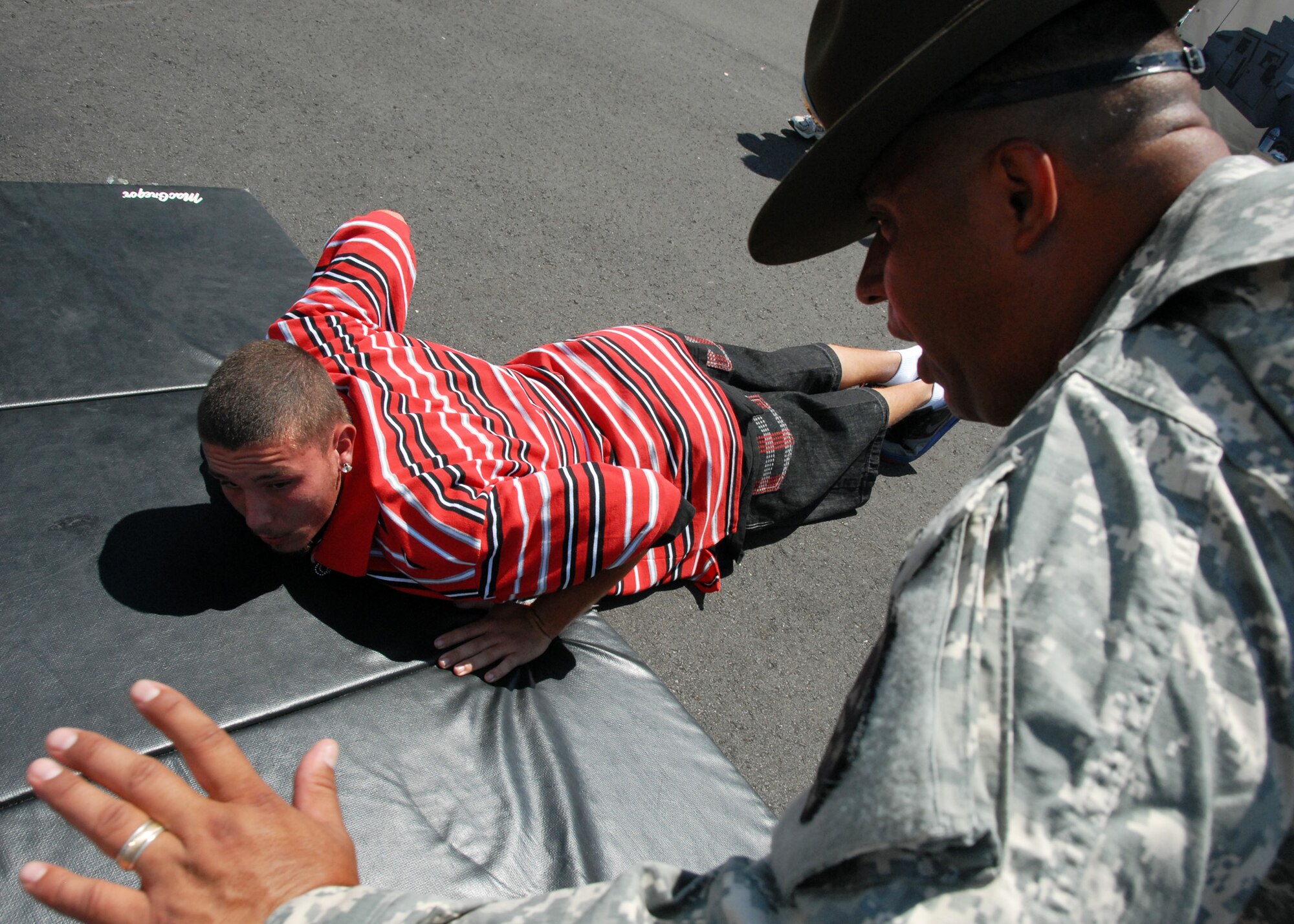 An Army recruiter shows the proper way to perform a push-up April 11 at the Eglin 75th Anniversary Air Show. More than 125,000 were in attendance for the show April 10-11, enjoying a variety of aerial performances and static displays. This was Eglin’s first open house since 2007 and was timed to coincide with the 75th anniversary of the installation. The Thunderbirds, Army Black Daggers, an F-22A Raptor demo and "Tora, Tora, Tora" were some of the highlights of the event. (U.S. Air Force photo/Samuel King Jr.) 