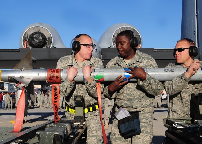 NELLIS AIR FORCE BASE, Nev. -- Senior Airman Edwin Karst,  Staff Sgt. Cir Thomas and Senior Airman Brendon Howbert carry an AIM 9 Side Winder missile to their A-10 Thunderbolt during a load crew competition, April 9, 2010.  (U.S. Air Force Photo by Staff Sgt. William P. Coleman)
