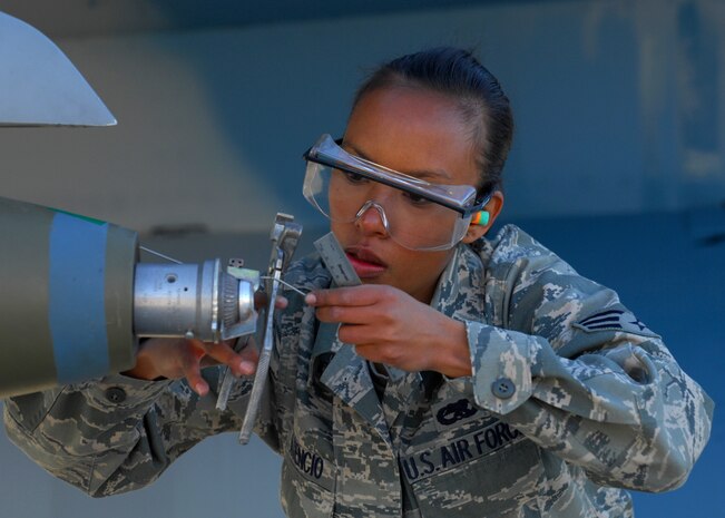 NELLIS AIR FORCE BASE, Nev. -- Senior Airman Michele Atencio, 57th Aircaft Maintenance Squadron Viper load crew member, loads a bomb onto an F-16 Fighting Falcon during a load crew competition, April 9, 2010.  Airman Atencio, along with her 57th AMXS Viper team mates: Staff Sgt. John Moyle and Airman 1st Class Nicholas Cunningham, won awards for best tool box and sharpest uniform.  (U.S. Air Force Photo by Staff Sgt. William P. Coleman)
