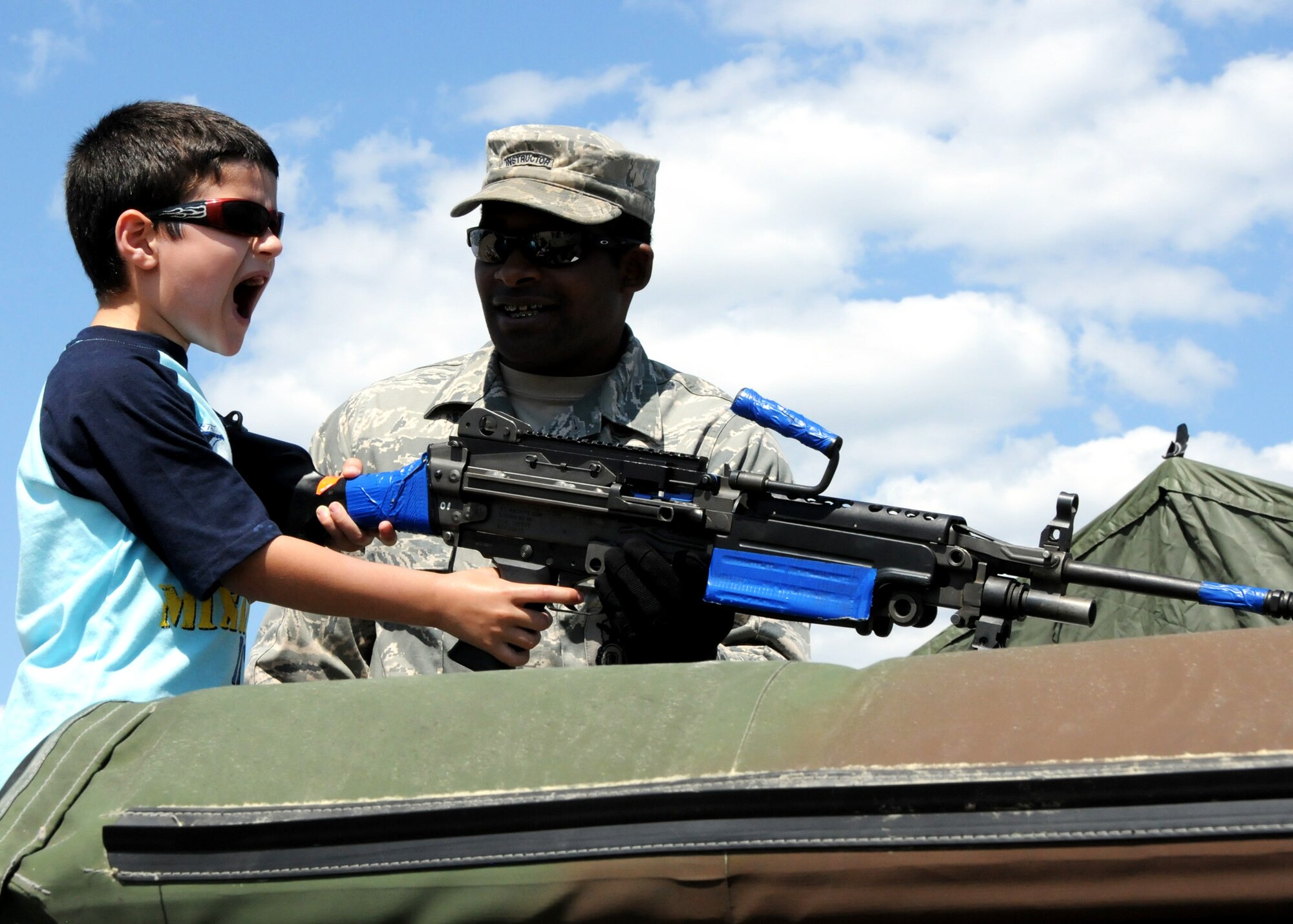 Matteo Incorvaia, pulls the trigger on the 50-caliber turret with the help of Staff Sgt. Ian Campbell, 96th Ground Combat Training Squadron, April 11 for the Eglin 75th Anniversary Air Show. More than 125,000 were in attendance for the show April 10-11, enjoying a variety of aerial performances and static displays. This was Eglin’s first open house since 2007 and was timed to coincide with the 75th anniversary of the installation. The Thunderbirds, Army Black Daggers, an F-22A Raptor demo and "Tora, Tora, Tora" were some of the highlights of the event. (U.S. Air Force photo/Tech. Sgt. Cheryl Foster) 