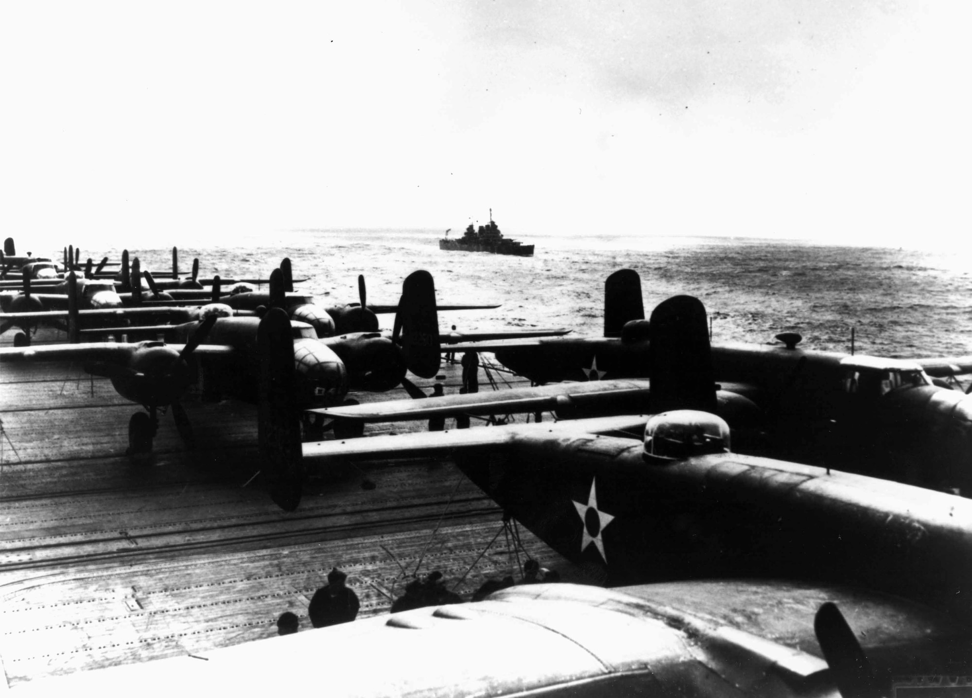 B-25 Mitchell bombers are tethered to the deck of the USS Hornet for their long trek from Calif. to Tokyo.  The bombers were modified to make them as light as possible and the tail guns were replaced with black painted broom handles to deter enemy fighters but to decrease take-off weight.  Later, newly promoted Brig. Gen James Doolittle, who led the raid, said the broom handles were surprisingly effective at deterring Japanese fighters. (Photo courtesy of 28th Bomb Wing historian’s office)