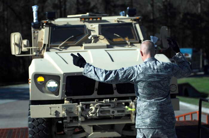 Airman 1st Class Koy Sauer directs the driver of a mine-resistant, ambush-protected all-terrain vehicle onto pallets at the 437th Aerial Port Squadron March 23, 2010, at Joint Base Charleston, S.C. The Air Force is supporting the Operation Enduring Freedom buildup by transporting M-ATVs into Afghanistan. Airman Sauer is an air transportation technician with the 437th Aerial Port Squadron. (U.S. Air Force photo/Senior Airman Timothy Taylor)