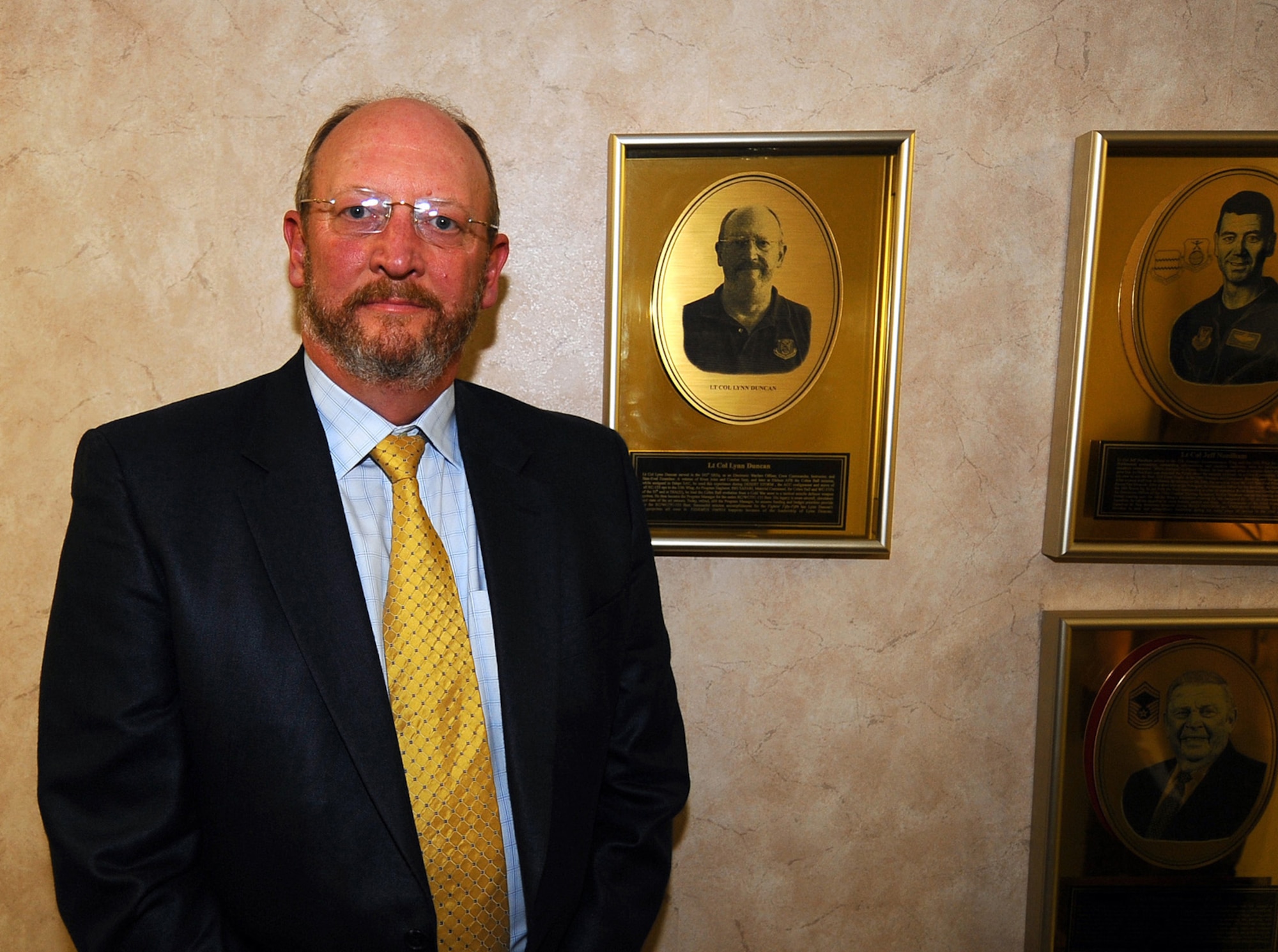 OFFUTT AIR FORCE BASE, Neb. -- Retired Lt. Col. Howard L. (Lynn) Duncan stands in front of his hall of fame plaque that commemorates his induction in the prestigious 55th Wing Hall of Fame inside the wing headquarters building here April 9. Colonel Duncan was awarded for serving the Fightin' Fifty-Fifth during his career, as well as his continued contributions following. U.S. Air Force photo by Josh Plueger
