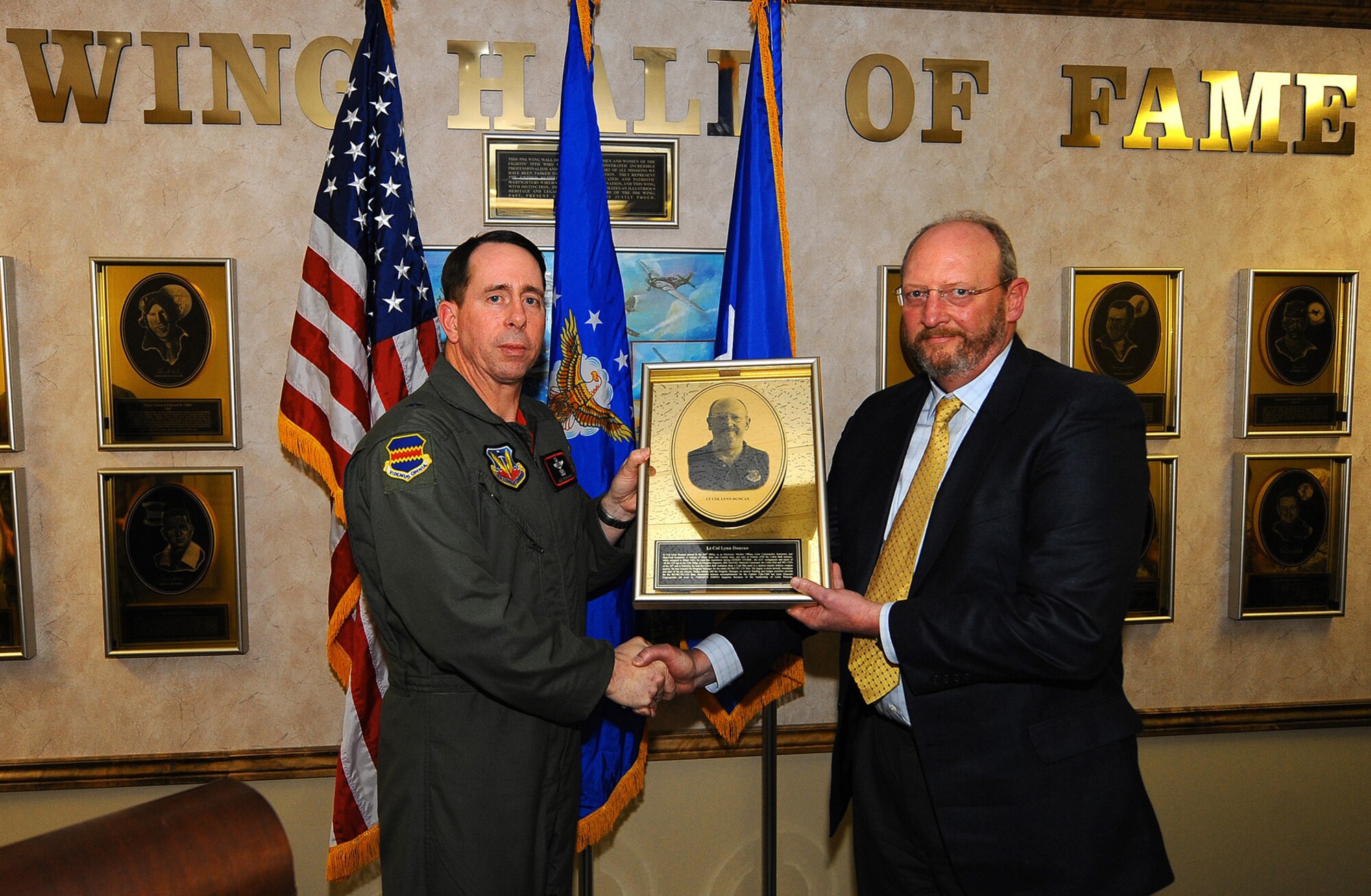 OFFUTT AIR FORCE BASE, Neb. -- Brig. Gen. John N.T. Shanahan, 55th Wing commander, presents a plaque to retired Lt. Col. Howard L. (Lynn) Duncan, officially inducting him into the prestigious 55th Wing Hall of Fame inside the wing headquarters building here April 9. Colonel Duncan was awarded for serving the Fightin' Fifty-Fifth during his career, as well as his continued contributions following. U.S. Air Force photo by Josh Plueger

