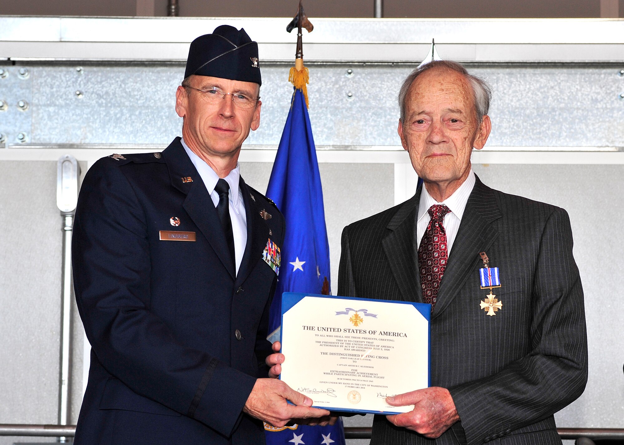 HOLLOMAN AIR FORCE BASE, N.M. -- Col. Donald Lindberg, 44th Fighter Group commander, presents the Distinguished Flying Cross first oak leaf cluster, to retired Capt. Arthur Kleiderer for distinguished service as group lead pilot for the 44th Bombardment Group during 14 combat missions near the conclusion of World War II. The 44th FG traces its lineage to the famed World War II 44th Bombardment Group (Heavy) originally activated in January 1941 at MacDill Army Air Field in Tampa Bay, Fla., and flew the then state-of-the-art B-17 Flying Fortress. Sixty-nine years later, the 44th FG is the only Air Force Reserve organization to be selected to fly the U.S. Air Force's premier air superiority fighter, the F-22 Raptor. (U.S. Air Force photo by Senior Airman DeAndre Curtiss / Released)