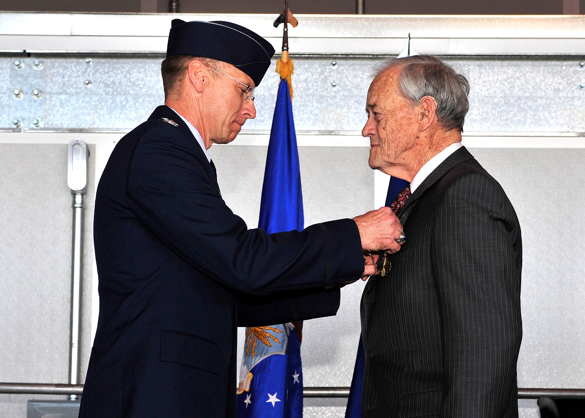 HOLLOMAN AIR FORCE BASE, N.M. -- Col. Donald Lindberg, 44th Fighter Group commander, presents the Distinguished Flying Cross first oak leaf cluster, to retired Capt. Arthur Kleiderer for distinguished service as group lead pilot for the 44th Bombardment Group during 14 combat missions near the conclusion of World War II. The 44th FG traces its lineage to the famed World War II 44th Bombardment Group (Heavy) originally activated in January 1941 at MacDill Army Air Field in Tampa Bay, Fla., and flew the then state-of-the-art B-17 Flying Fortress. Sixty-nine years later, the 44th FG is the only Air Force Reserve organization to be selected to fly the U.S. Air Force's premier air superiority fighter, the F-22 Raptor. (U.S. Air Force photo by Senior Airman DeAndre Curtiss / Released)