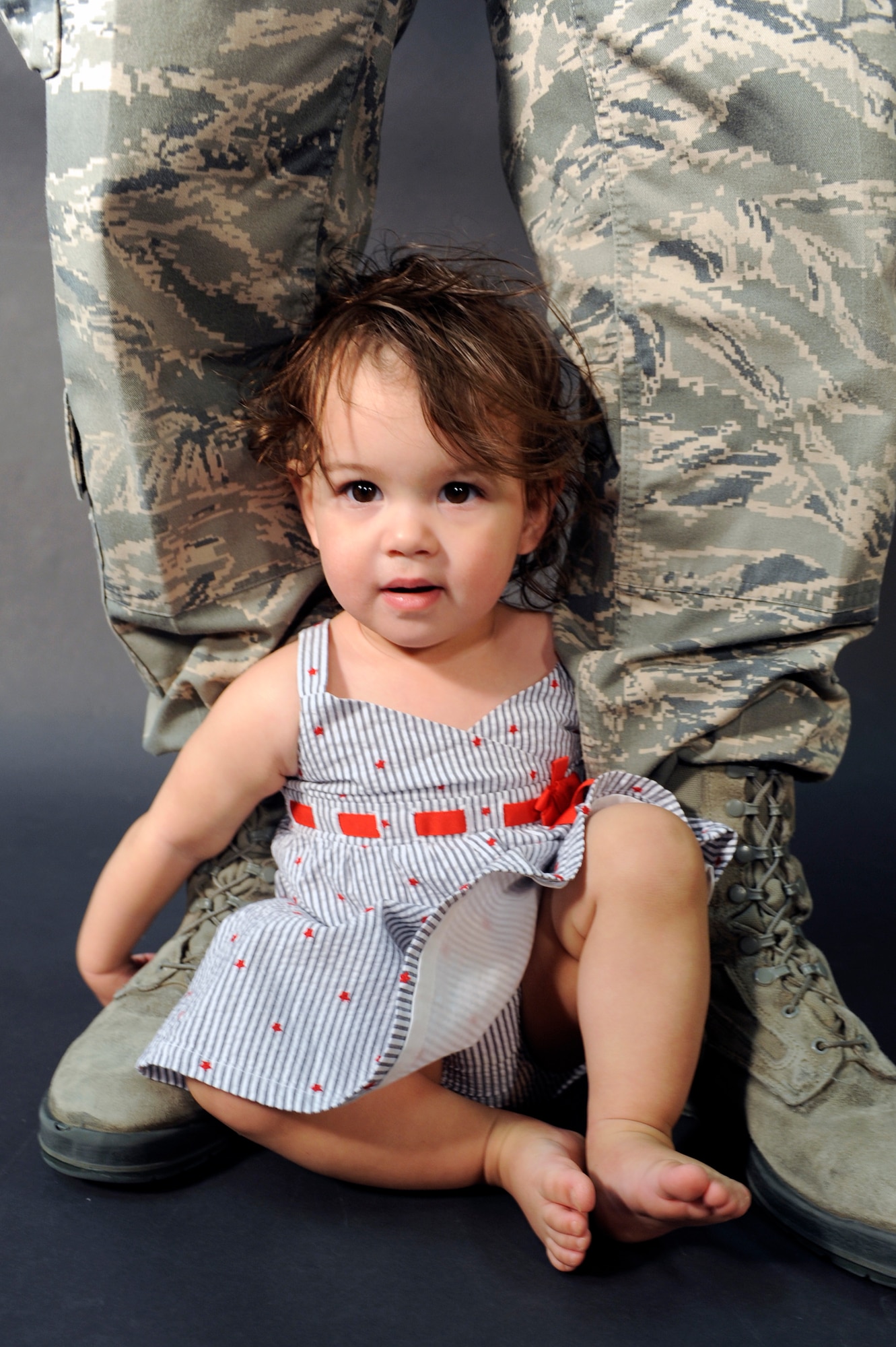 ELLSWORTH AIR FORCE BASE S.D. -- The daughter of an Ellsworth Airman sits at her father’s feet, April 8.  April has been designated as the Month of the Military Child to honor the sacrifices children make while Airmen serve their country. (U.S. Air Force photo/Senior Airman Marc I. Lane)