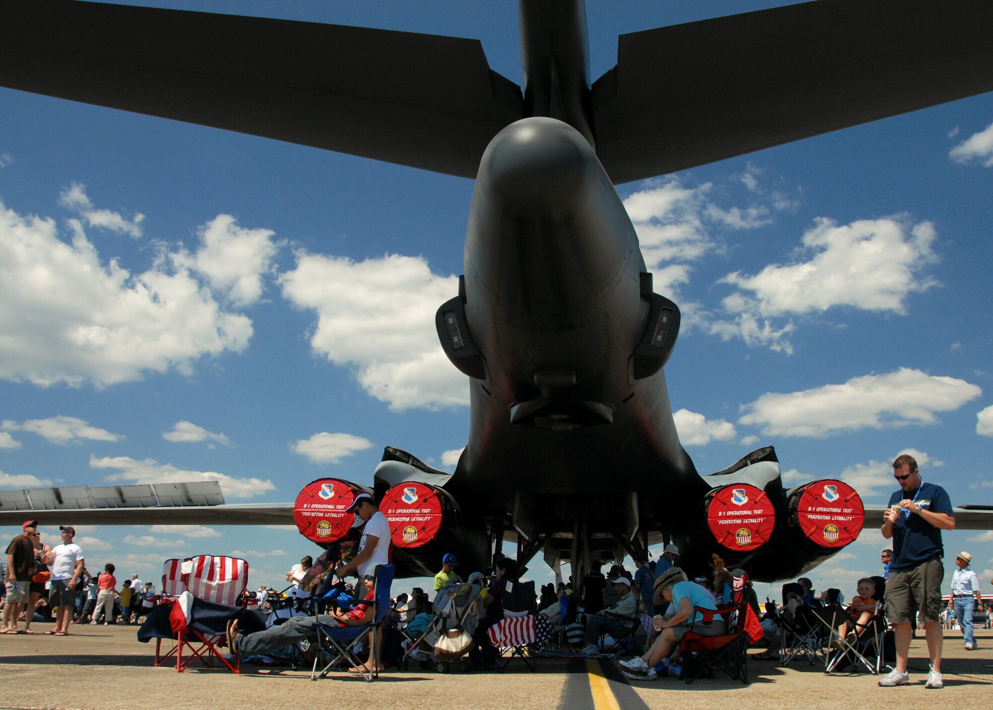 Spectators hid from the sun under the tail of a B-1B Lancer at the 75th Anniversary Air Show April 11. More than 125,000 were in attendance during the air show April 10-11, enjoying a variety of aerial performances and static displays. This was Eglin’s first open house since 2007 and was timed to coincide with the 75th anniversary of the installation. The F-22A Raptor demo, Army Black Daggers and "Tora, Tora, Tora" were some of the highlights of the event. (U.S. Air Force photo/ Samuel King Jr.)
