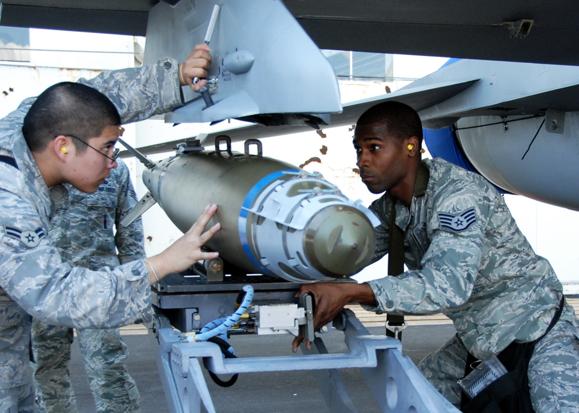 Airman 1st Class Victor Gonzalez and Staff Sgt. Chris Nelloms, 46th Test Wing, load a bomb on to an aircraft April 11 for the Eglin 75th Anniversary Air Show. More than 125,000 were in attendance for the show April 10-11, enjoying a variety of aerial performances and static displays. This was Eglin’s first open house since 2007 and was timed to coincide with the 75th anniversary of the installation. The Thunderbirds, Army Black Daggers, an F-22A Raptor demo and "Tora, Tora, Tora" were some of the highlights of the event. (U.S. Air Force photo/Samuel King Jr.) 