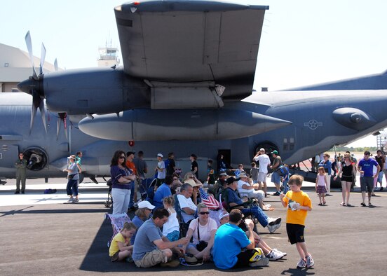 Spectators hide underneath the wing of a C-130 April 11 for the Eglin 75th Anniversary Air Show. More than 125,000 were in attendance for the show April 10-11, enjoying a variety of aerial performances and static displays. This was Eglin’s first open house since 2007 and was timed to coincide with the 75th anniversary of the installation. The Thunderbirds, Army Black Daggers, an F-22A Raptor demo and "Tora, Tora, Tora" were some of the highlights of the event. (U.S. Air Force photo/Samuel King Jr.) 