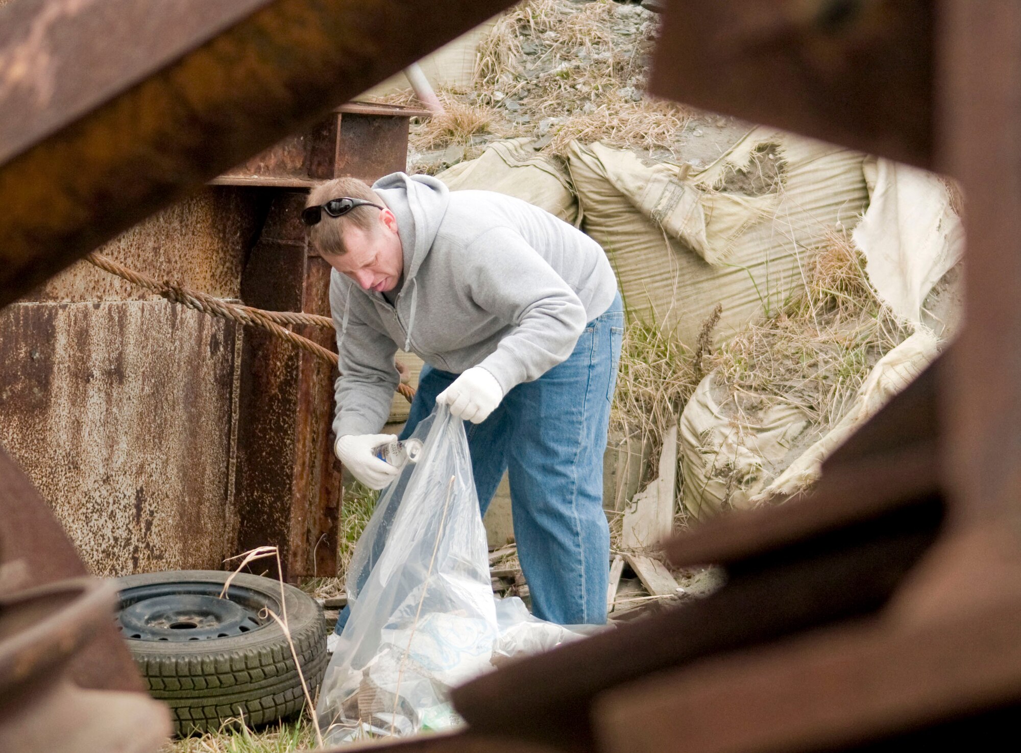 Master Sgt. Brian Spalding loads trash into a plastic bag during the 13th Annual Misawa port and beach cleanup at Misawa Air Base, Japan, April 10, 2010.  Sergeant Spalding is assigned to the 35th Fighter Wing Flight Safety office. (U.S. Air Force photo/Senior Airman Jessica Lockoski)