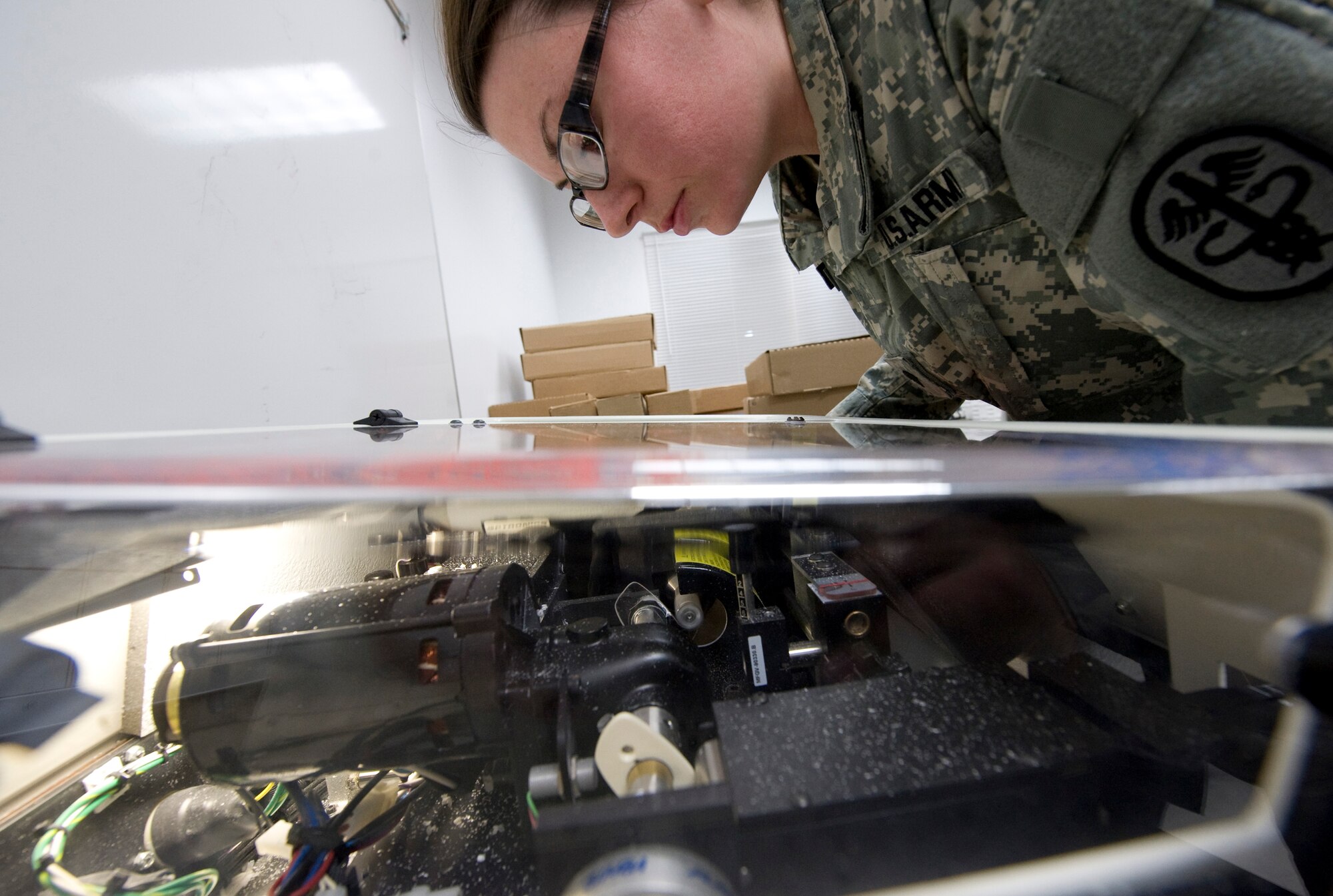 Army Spc. Alisha Weatherby uses a Horizon II edger to cut a new eyeglass lens during Operation Arctic Care April 12, 2010, in Kotzebue, Alaska. Specialist Weatherby is an optical lab specialist from the Naval Ophthalmic Support and Training Activity in Yorktown, Va. (U.S. Air Force photo/Master Sgt. Jack Braden)