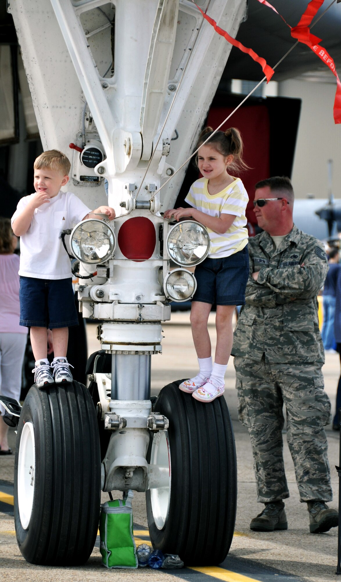 Children watch the show on top of the wheels of an aircraft display April 10 at the Eglin 75th Anniversary Air Show. More than 125,000 were in attendance for the show April 10-11, enjoying a variety of aerial performances and static displays. This is Eglin’s first open house since 2007 and was timed to coincide with the 75th anniversary of the installation. The Thunderbirds, Army Black Daggers, an F-22A Raptor demo and "Tora, Tora, Tora" were some of the highlights of the event. (U.S. Air Force photo/Airman 1st Class Rachelle Elsea.)