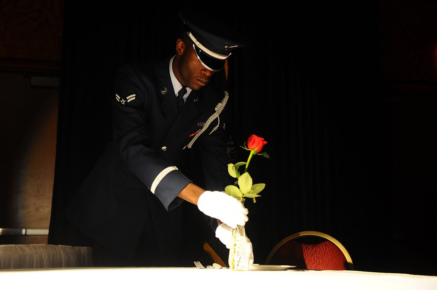 OFFUTT AIR FORCE BASE, Neb. ? Airman 1st Class Cameron T. Spencer, 55th Wing Honor Guard, places a rose into a vase on the Prisoners of War table during the 2010 55th Wing Birthday Ball at Embassy Suites in La Vista, Neb., April 10. The placing of the rose symbolizes the hope that families and loved ones have for the safe return of servicemembers who are POWs or missing in action. More than 800 members of Team Offutt attended the ball to honor the wing?s past and celebrate the current role of the Fightin Fifty-Fifth in today?s Air Force. U.S. Air Force photo by Josh Plueger