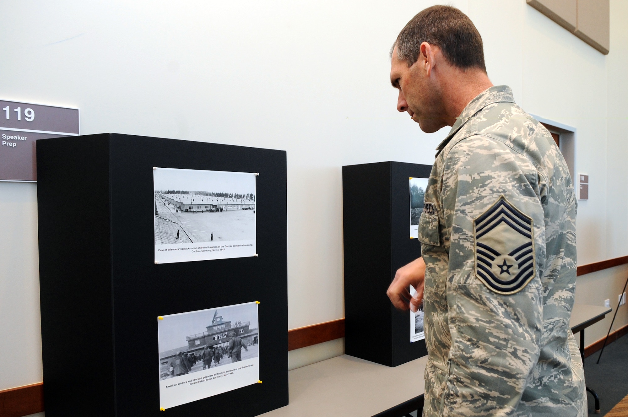 BUCKLEY AIR FORCE BASE, Colo. -- Chief Master Sgt. Todd Kennedy, 460th Operations Group superintendent, views photos of Holocaust victims April 9. A display was set up in the Leadership Development Center as part of the Days of Remembrance. (U.S. Air Force Photo by Airman 1st Class Marcy Glass)
