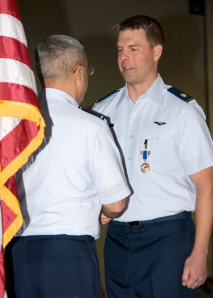 Brig. Gen. Michael Colangelo, the Arizona Air National Guard commander, presents an Air Medal to Maj. Matthew Garrison, an F-16 instructor pilot at the 162nd Fighter Wing, April 10. During its annual awards ceremony the Arizona Air National Guard unit based at Tucson International Airport recognized 57 Guardsmen and civilian supporters for outstanding contributions to the wing mission. (Air Force photo by Master Sgt. Dave Neve)