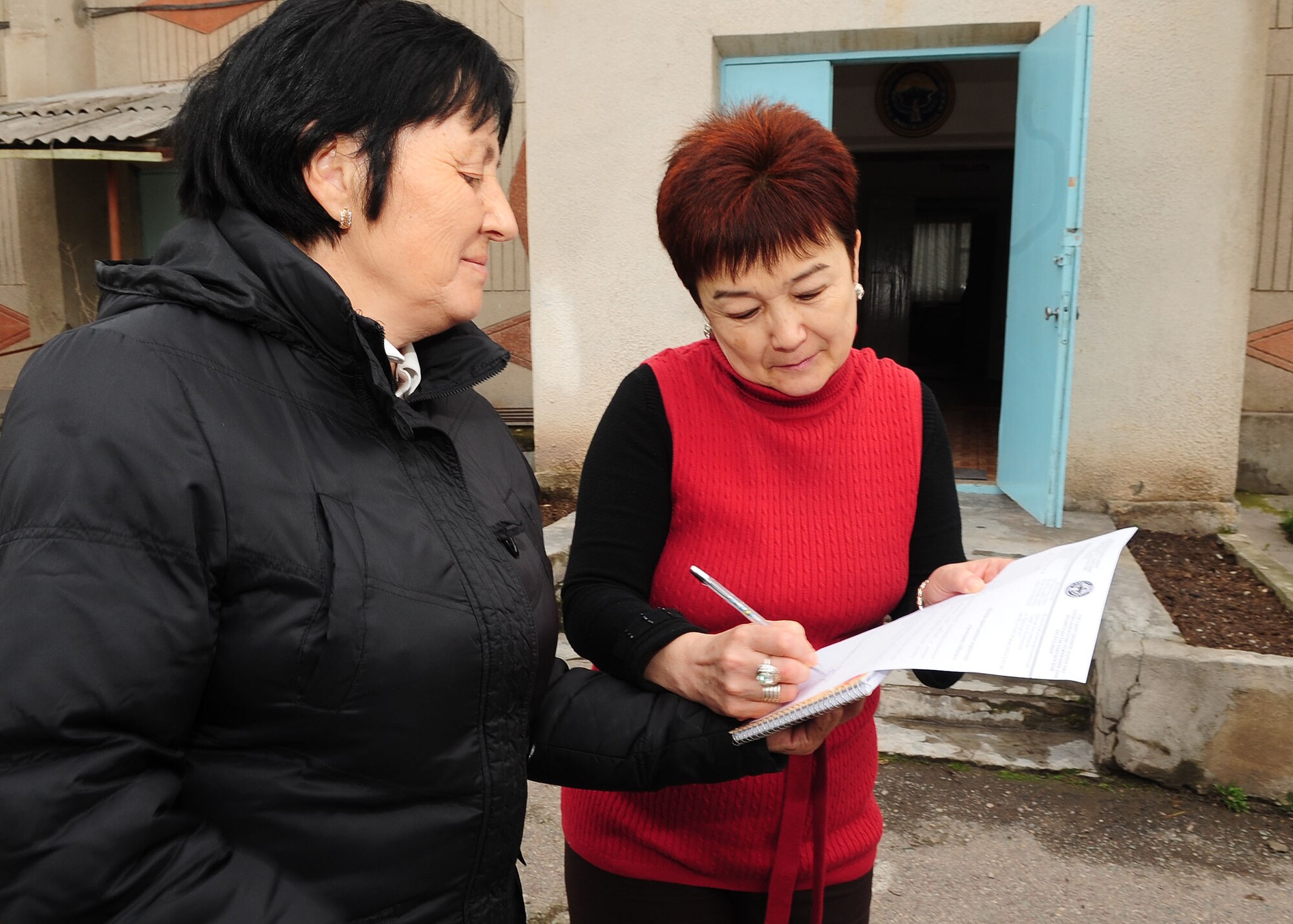 Svetlana Beyshenalieva, Belovodsky Orphanage director, signs a thank you letter to give to the Airmen of the Transit Center at Manas, Kyrgyzstan, via Valentina Turabekova, Kyrgyz advisor, April 13, 2010. U.S. Airmen from the Transit Center collected 8,000 COM (almost $200) and bought the orphanage basic items including sugar, rice, beans, tea, clothing and other necessities. Some donations were also given by Americans stateside for this and other humanitarian assistance projects in the city and surrounding areas. (U.S. Air Force photo/Senior Airman Nichelle Anderson/released)