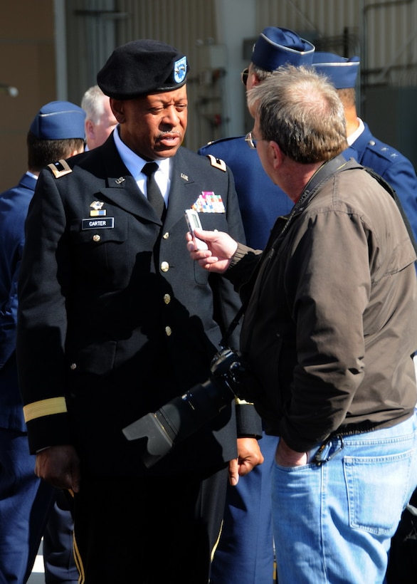 Maj. Gen.  Joseph Carter, the MA Adjutant General, is interviewed by Westfield News photographer Mr. Fred Gore in front of the new Air Sovereignty Alert hangar at the 104th Fighter Wing, Massachusetts Air National Guard base in Westfield Massachusetts on April 10, 2010 just after the official ribbon cutting ceremony.  The wing officially accepted the alert mission on February 15, 2010, and stands ready to defend the homeland if called upon.  (photograph by Senior Master Sgt. Robert J. Sabonis)