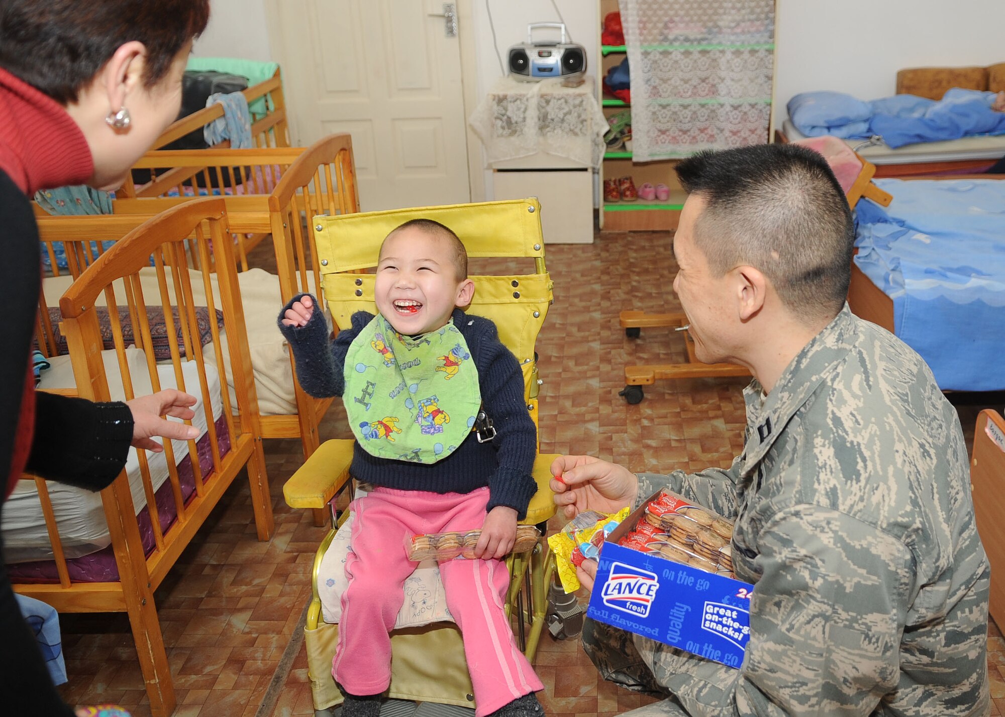 U.S. Air Force Capt. Alan Yee, the executive officer for the director of the Transit Center at Manas, Kyrgyzstan, brings a smile to the face of a young boy at the Belovodsky Orphanage April 13, 2010. U.S. Airmen from the Transit Center collected 8,000 COM (almost $200) and bought the orphanage basic items including sugar, rice, beans, tea, clothing and other necessities. Some donations were also given by Americans stateside for this and other humanitarian assistance projects in the city and surrounding areas. (U.S. Air Force photo/Senior Airman Nichelle Anderson/released)