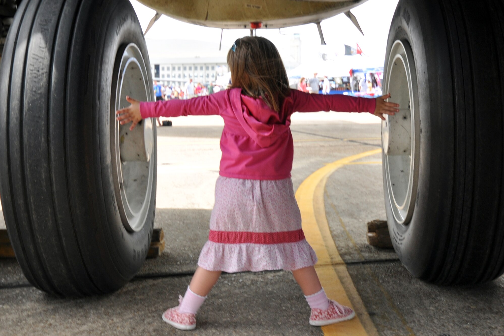 An airshow patron measures the wheel distance of a B-52 Stratofortress displayed at the Eglin 75th Anniversary Air Show April 10.  More than 125,000 were in attendance April 10-11, enjoying a variety of aerial performances and static displays. This was Eglin’s first open house since 2007 and was timed to coincide with the 75th anniversary of the installation. The Thunderbirds, Army Black Daggers, an F-22A Raptor demo and "Tora, Tora, Tora" were some of the highlights of the event. (U.S. Air Force photo/Airman 1st Class Anthony Jennings.) 