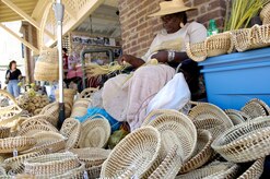 Shirley Manigault sits surrounded by hand woven baskets on Market Street in downtown Charleston, S.C., April 1, 2010. Sea Island basket weaving is a folk tradition whose origins date back to the end of the 17th century. This art form was born out of the rise of South Carolinian rice cultivation during the 1680s. Originally known as fanners, the circular baskets were approximately two feet in diameter and used as tools for winnowing rice. The traditional artists displays are one of many sites to behold on the Newcomer?s Tour sponsored by the Airman and Family Readiness Center on Joint Base Charleston. The tour is free and offered to all service members and their families. (U.S. Air Force Photo/Airman 1st Class Lauren Main)