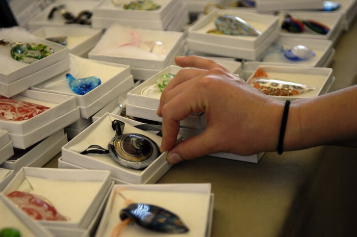 Second Lieutenant Susan Carlson reaches for a blown glass necklace while on a shopping excursion during the Newcomer?s Tour in downtown Charleston, S.C., April 1, 2010. The tour is sponsored by the Airman and Family Readiness Center and is a day-long outing, which consists of walking tours, food, shopping and a chartered tour through the oldest historical neighborhoods in America. Charleston is also home to numerous filming sites for the movie ?The Notebook.? (U.S. Air Force Photo/Airman 1st Class Lauren Main)