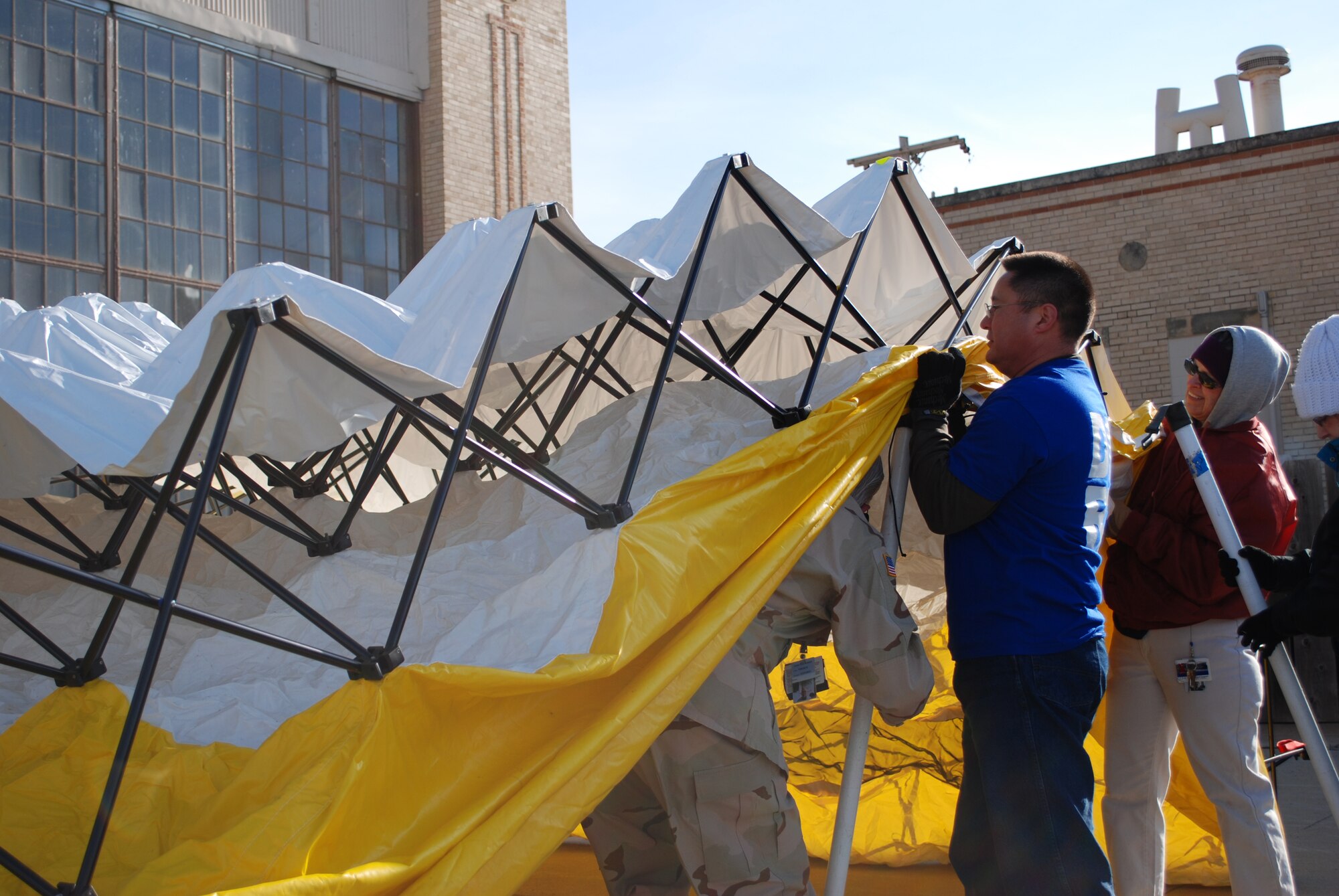 Exercise participants from the Robert J. Dole Veterans Affairs Medical Center construct a medical triage tent during a National Disaster Medical System activation exercise April 8, 2010, McConnell Air Force Base, Kan.  The exercise was used to evaluate inter-agency coordination following a simulated earthquake in the Missouri River Valley. (U.S. Air Force photo/2nd Lt. Nicholas Mercurio)