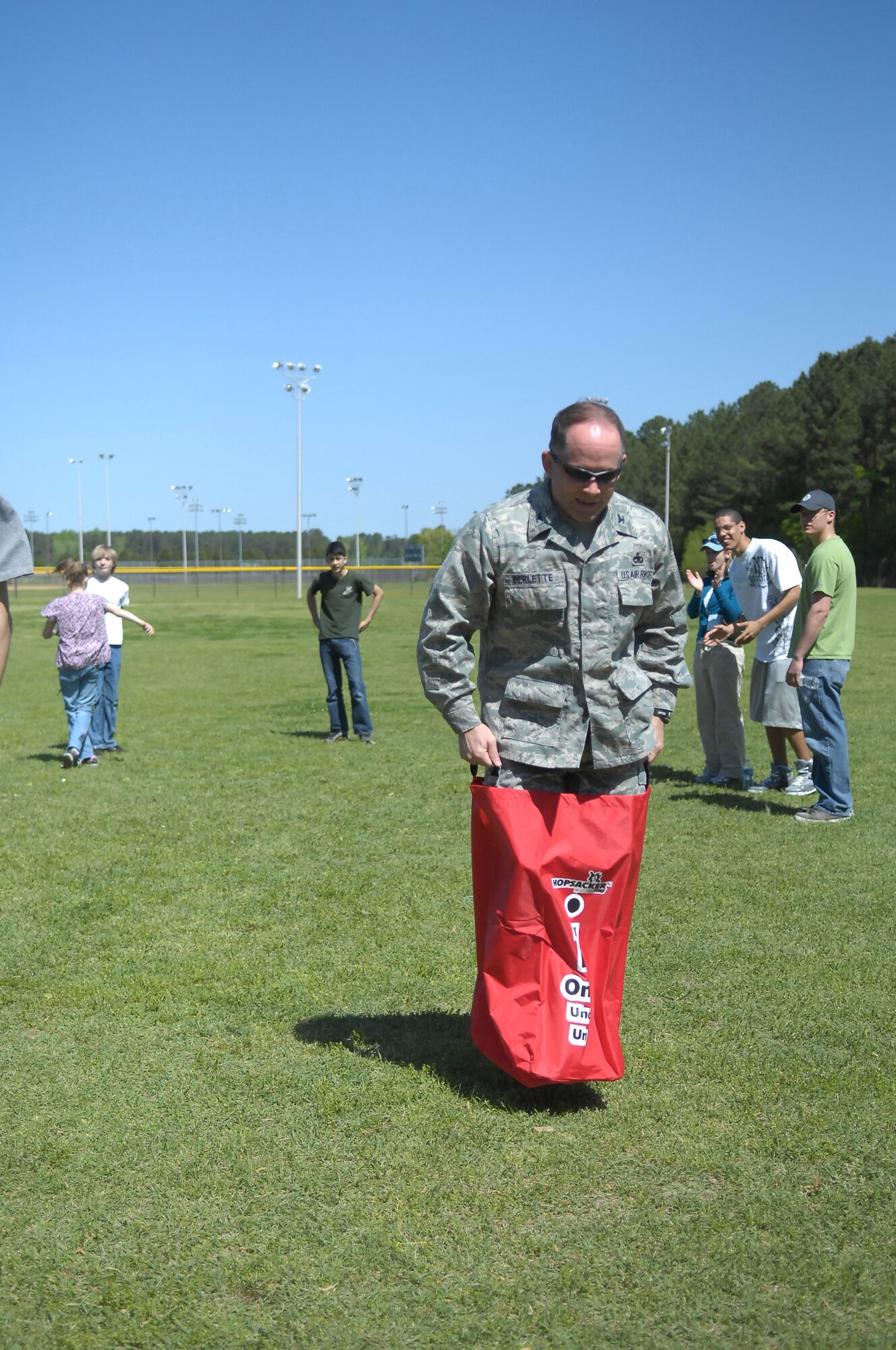 Col. Craig Berlette, 43rd Airlift Wing, Vice Commander, jumps into second place at the adult category potato sack race at Pope’s Annual Spring Fling and Furry Friends Walk at Pope April 10. Along with the walk, the day included several events such as a bouncy castle, arts and crafts, family kickball and a potato sack race. All members of the family were invited, pets included. (U.S. Air Force photo by 2nd Lt. Cammie Quinn)