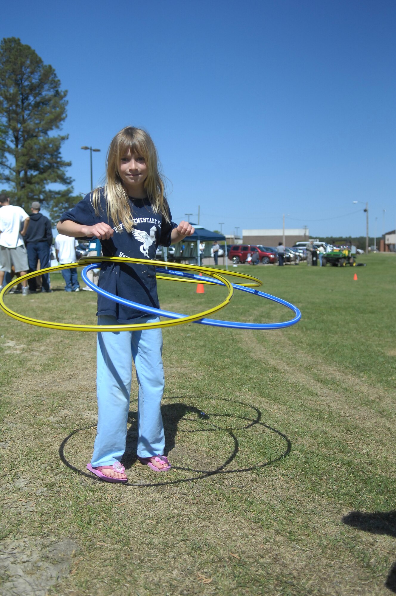 Audrey Rose Mudford, 7, hula hoops with a record setting, three hoops at Pope’s Annual Spring Fling and Furry Friends Walk at Pope April 10. Along with the walk, the day included several events such as a bouncy castle, arts and crafts, family kickball and a potato sack race. All members of the family were invited, pets included. (U.S. Air Force photo by 2nd Lt. Cammie Quinn)