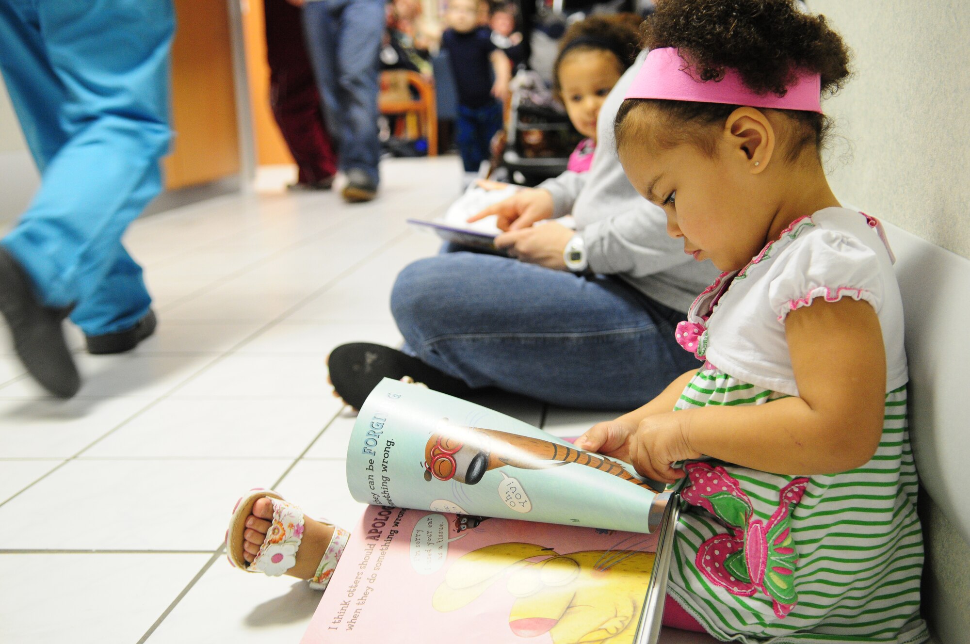 Regan Spence, 5, daughter of Megan Spence, reads in the hallway during "Little Teeth Big Smiles", Ramstein Air Base, Germany, April 12, 2010. This bi-annual event is hosted by the 86th Dental Squadron, it serves approximately 200 children and their family in the Kaiserslautern Military Community. (U.S. Air Force photo by Airman 1st Class Desiree Esposito)