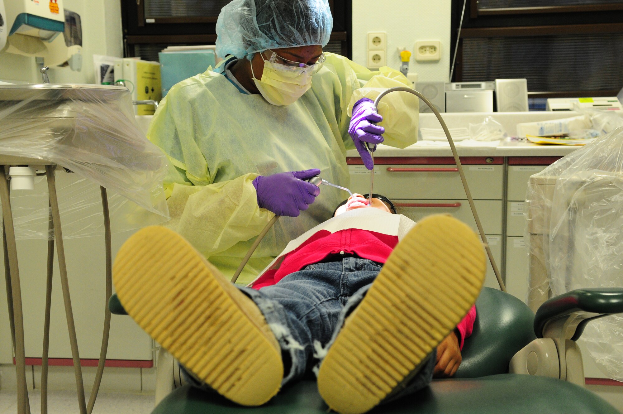 U.S. Air Force Airman 1st Class Alexis Brown, 86th Dental Squadron dental assistant journeyman, provides a teeth cleaning to Elizabeth Lopez, 5, daughter of Capt. Edgar Lopez, 86th Airlift Wing, Ramstein Air Base, Germany, April 12, 2010. The 86th Dental Squadron serves approximately 200 children and their family in the Kaiserslautern Military Community during their bi-annual event, "Little Teeth Big Smiles". (U.S. Air Force photo by Airman 1st Class Desiree Esposito)