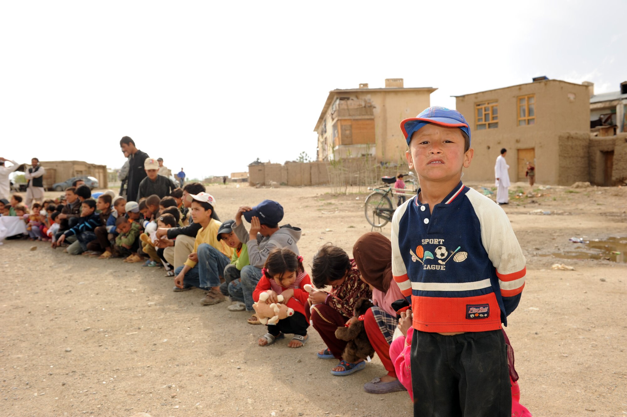 An Afghan child stops to pose for a picture while waiting to receive a stuffed animal during a recent Operation Care humanitarian mission at Bagram Airfield, Afghanistan. Operation Care is an all volunteer nonprofit organization made up of servicemembers and civilians, whose mission is to provide humanitarian assistance to  local civilians in remote areas of Afghanistan. (U.S. Air Force photo by/ Staff Sgt. Richard Williams)
