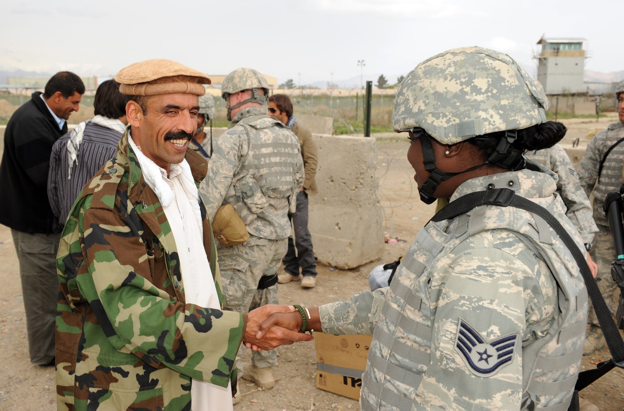A village resident greets U.S. Staff Sgt. Ndeye Silla, 577th Expeditionary Prime Beef Squadron, during an Operation Care humanitarian aid mission at Bagram Airfield, Afghanistan. Sergeant Silla is deployed from Lackland Air Force Base, Texas and is a native of Dakar, Senegal. (U.S. Air Force photo by/ Staff Sgt. Richard Williams)