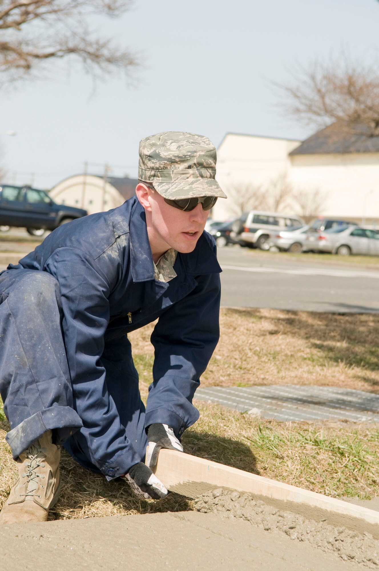 MISAWA AIR BASE, Japan – Airman 1st Class Ryan Simpson, 35th Civil Engineering Squadron pavement and equipment operator, levels out freshly poured concrete with a screedboard, April 9 alongside Freedom Drive. Airmen in the pavement and construction career field maintain roads, asphalt runways and sidewalks. (U.S. Air Force photo/Senior Airman Jessica Lockoski)


