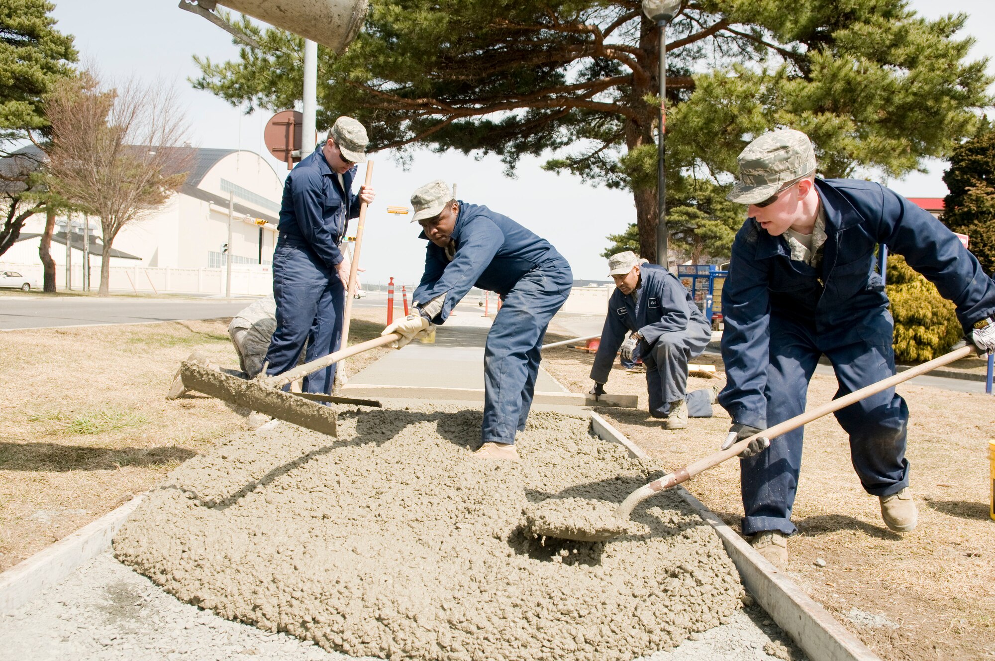 MISAWA AIR BASE, Japan – 35th Civil Engineering Squadron pavement and equipment operators spread wet concrete into a sidewalk mold, April 9 along Freedom Drive. The Airmen replaced 150 feet of sidewalk during the project and used nine cubic meters of concrete. (U.S. Air Force photo/Senior Airman Jessica Lockoski)