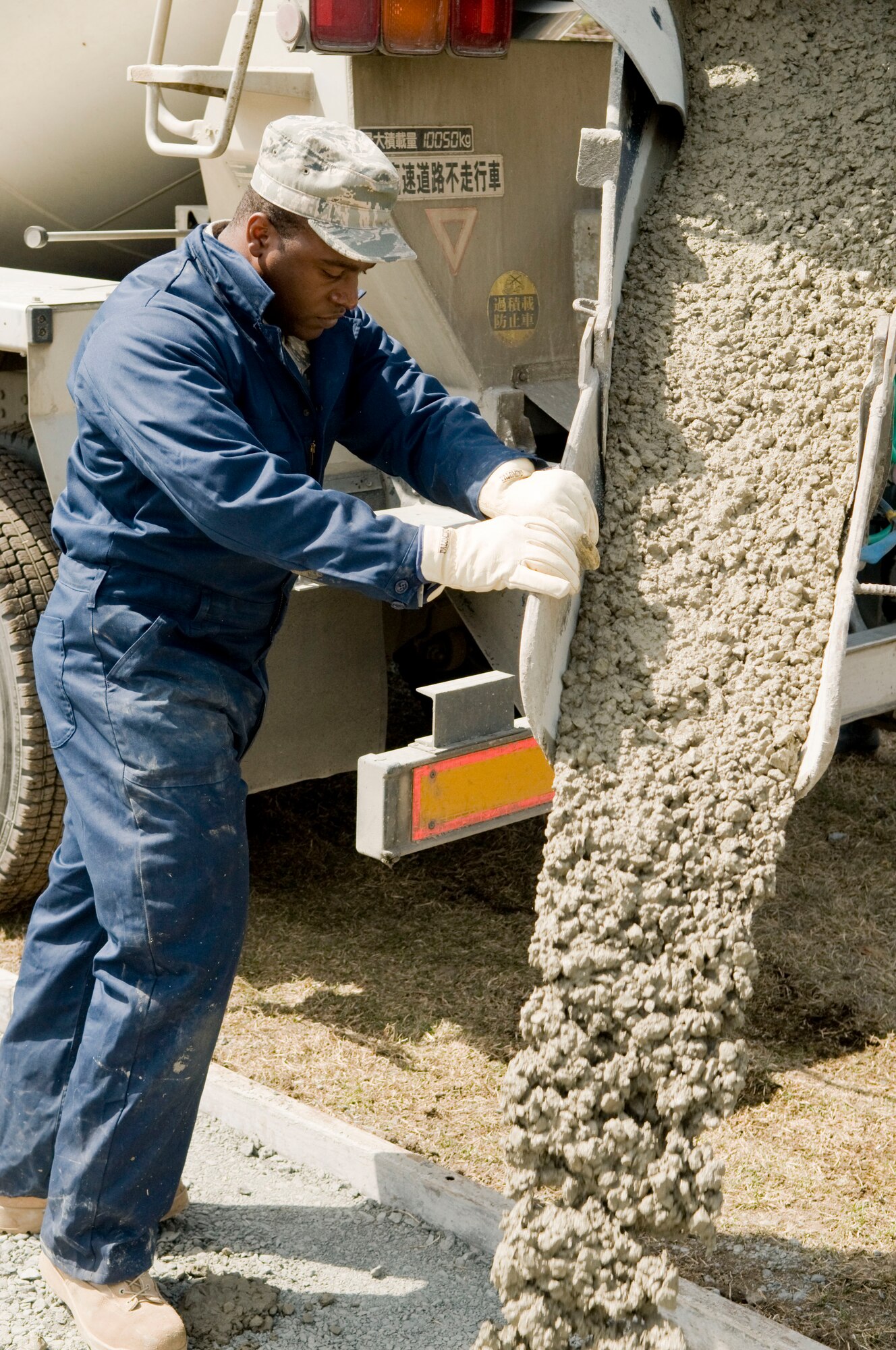 MISAWA AIR BASE, Japan – Staff Sgt. Reginald Athouriste, 35th Civil Engineer Squadron pavement and equipment operator, guides concrete in a sidewalk mold, April 9 alongside Freedom Drive. Airmen from the 35th CES lay asphalt for parking lots on base and fulfill10 to 20 sidewalk work requests each month. (U.S. Air Force photo/Senior Airman Jessica Lockoski)