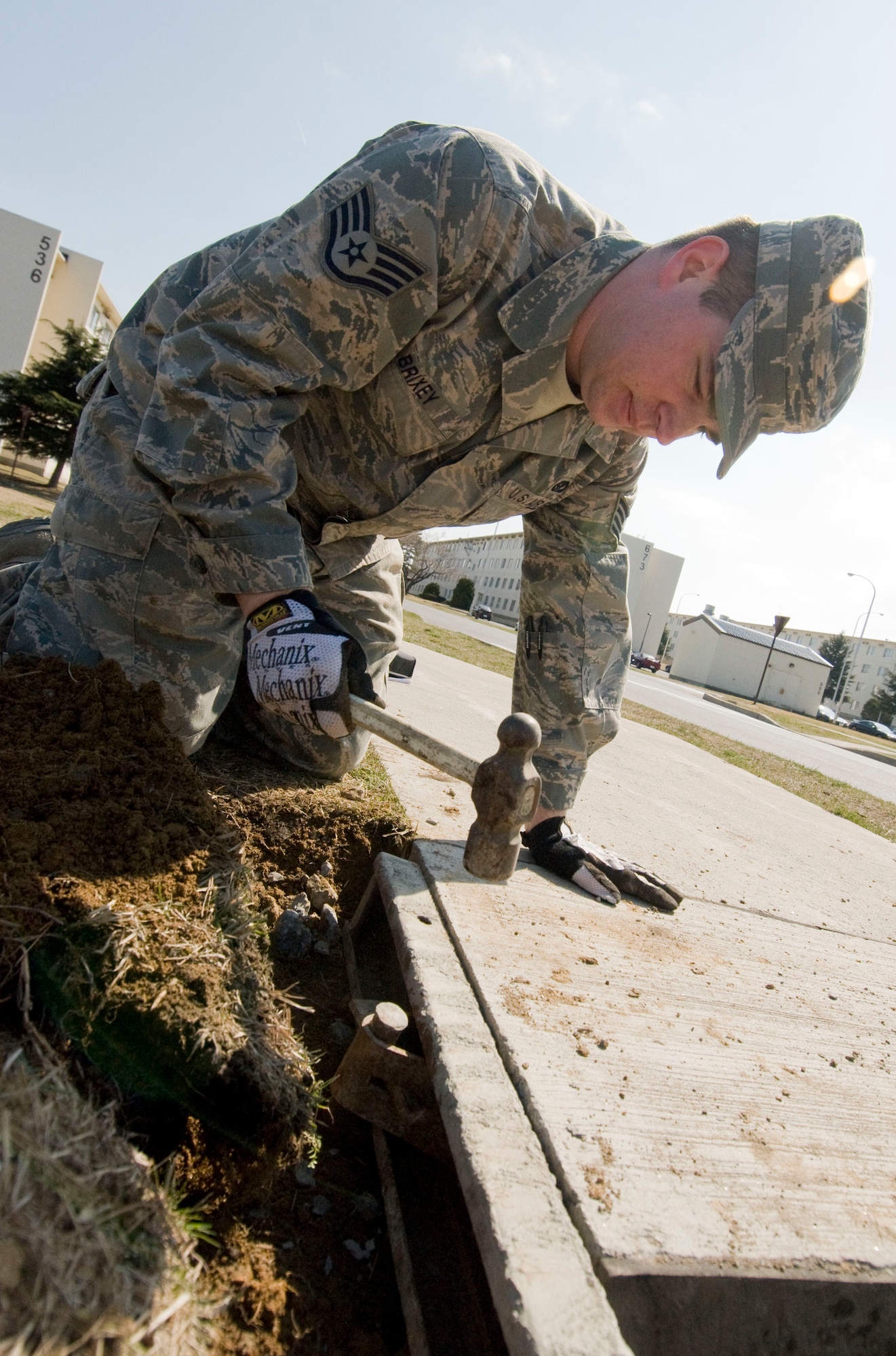 MISAWA AIR BASE, Japan -- Staff Sgt. Lennon Brixey, 35th Civil Engineer Squadron pavement and equipment operator, places sidewalk mold into the ground, April 8 alongside Freedom Drive. Airmen from 35th CES replaced an uneven section of sidewalk that posed a hazard for Misawa Air Base residents. (U.S. Air Force photo/Senior Airman Jessica Lockoski)