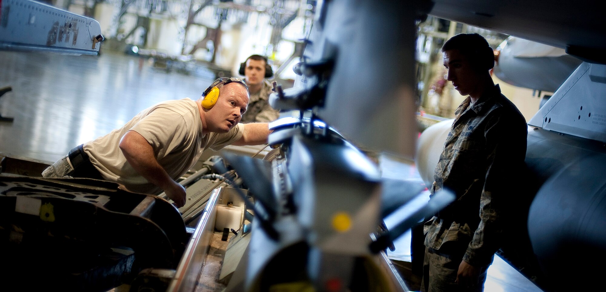 MISAWA AIR BASE, Japan -- Staff Sgt. Christopher Durden, Airmen 1st Class Benjamin Fisher and Paul Callahan, 13th Aircraft Maintenance Unit load crew members, load a GBU-31 joint direct attack munition during a load crew competition Apr. 9. The 13th AMU load crew team was bested by the 14th AMU. (U.S. Air Force photo/Staff Sgt. Chad C. Strohmeyer)