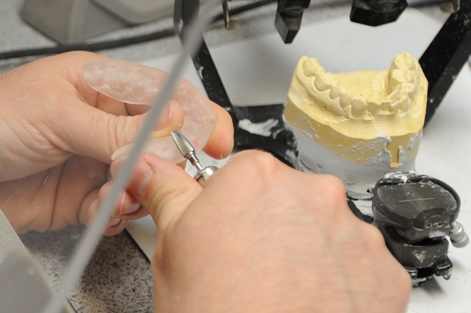WHITEMAN AIR FORCE BASE, Mo. - Staff Sgt. James Anderson, 509th Medical Operation Squadron dental lab technician, carefully smoothes out the surfaces of a night guard to ensure a tight fit on the patient's teeth, April 9, 2010. Sergeant Anderson has to repeat this several times until the surface is just right. (U.S. Air Force photo/ Airman 1st Class Carlin Leslie) (Released) 