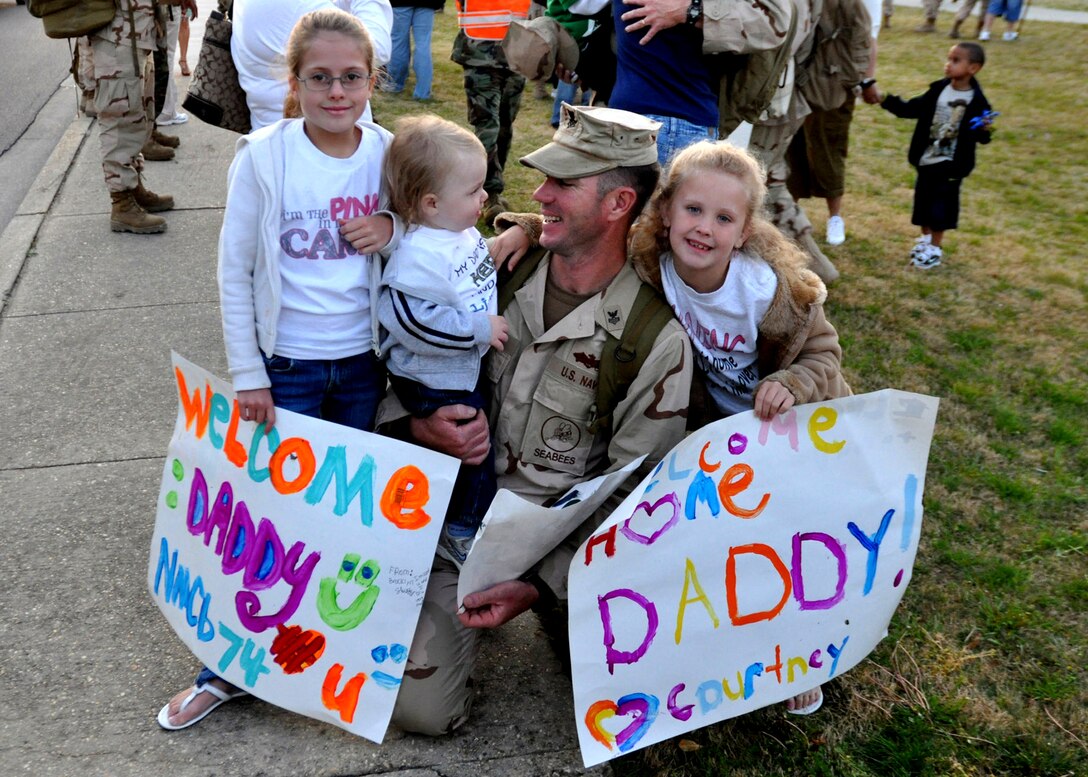 U.S. Navy Petty Officer 2nd Class Jason Shurtz embraces his two daughters and son at the training hall on board Naval Construction Battalion Center in Gulfport, Miss., March 31, 2010. Naval Mobile Construction Battalion 74 is returning from an eight-month deployment to support contingency operations in the Central Command area of responsibility.
