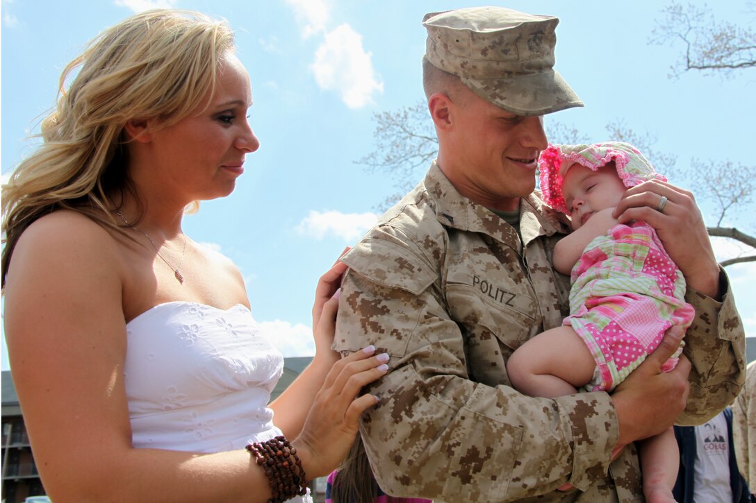 U.S. Marine Corps Lance Cpl. Ryan L. Politz hugs his daughter, Lorelai, at the Marine Aircraft Logistics Squadron 40 homecoming on U.S. Marine Corps Air Station Cherry Point,  March 26, 2010. Politz’s wife, Sinead, left, and their daughter were one of many families at the homecoming. Politz  is a mobile facility technician.
