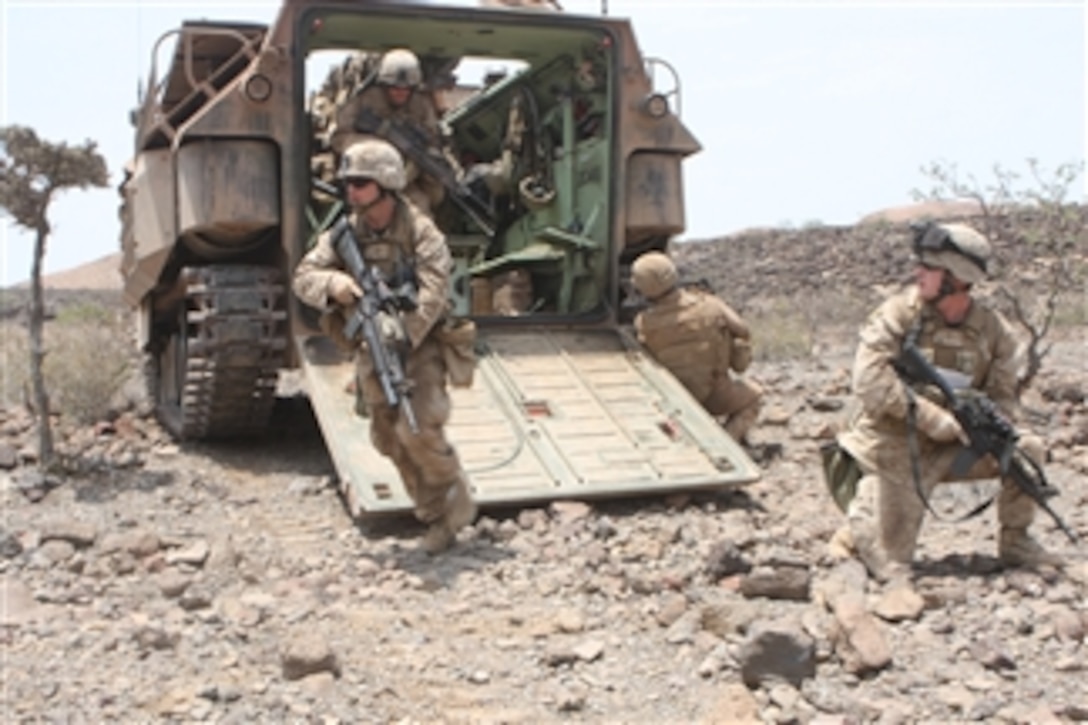 U.S. Marine Corps Cpl. Daniel Mallory, a squad leader with 1st Platoon, Alpha Company, Battalion Landing Team, 1st Battalion, 9th Marine Regiment, 24th Marine Expeditionary Unit, secures the rear of an amphibious assault vehicle while Lance Cpl. Daniel Pursley leads his team toward an objective during a mechanized assault in Djibouti on March 29, 2010.  The 24th Marine Expeditionary Unit serves as the theater reserve force for Central Command during its seven-month deployment aboard Nassau Amphibious Ready Group vessels.  