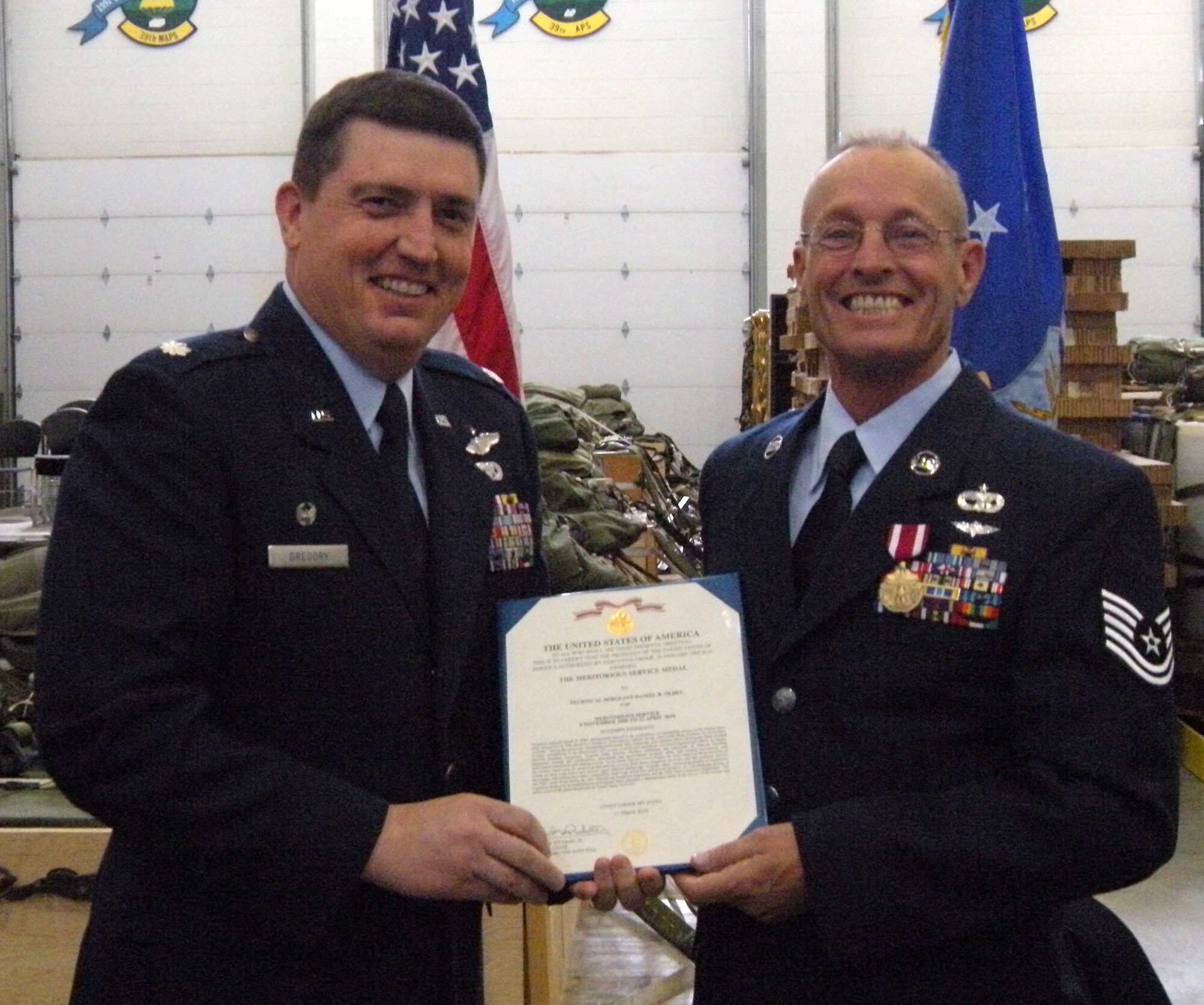 Tech. Sgt. Dan Oldes (right) accepts his last medal from Lt. Col. James Gregory, 39th Aerial Port Squadron commander, before his retirement ceremony April 11 at Peterson Air Force Base, Colo. Air Force Reservists assigned to the 302nd Airlift Wing interested in capturing special occasions or ceremonies within their respective organizations can check out a Nikon "point and click" camera from the Public Affairs office as part of the office's self-help camera program. Those interested can visit the PA office in Bldg. 893, Rm. 137, or call (719) 556-4117 for more details. Members are reminded the self-help cameras are to be used for official use only. Sergeant Oldes, who served in the military for 23 years, was recognized with the ceremony during the Sunday of the 302nd Airlift Wing's April Unit Training Assembly. Sergeant Oldes was assigned to the 39th APS. (Courtesy photo)