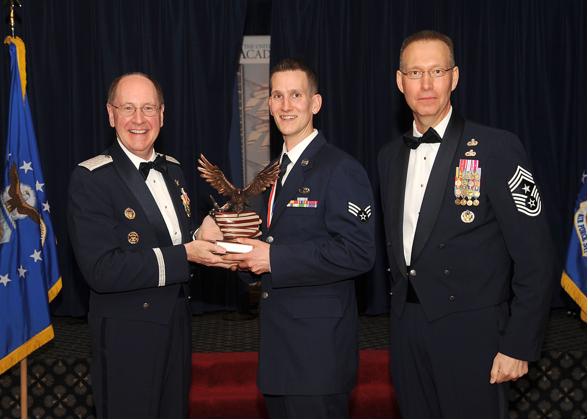 PETERSON AIR FORCE BASE, Colo. -- Senior Airman Robert Kafka accepts his 2009 Air Force Space Command Airman of the Year trophy from Gen. C. Robert Kehler, AFSPC commander, and Chief Master Sgt. Richard Small, AFSPC command chief, during an awards banquet April 9. (U.S. Air Force photo by Tech. Sgt. Matthew Lohr) 