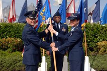 Col. Charles Baumgardner, 15th Mission Support Group commander (left), presents the 15th Force Support Squadron guidon to Lt. Col. Carey Eichhorst, 15 FSS commander, after she assumed command of the unit at the 15 FSS Assumption of Command ceremony here April 14. During the ceremony, the 15 MSS and the 15 SVS were deactivated and then re-activated jointly as the 15 FSS. (U.S. Air Force photo by Senior Airman Nathan Allen)