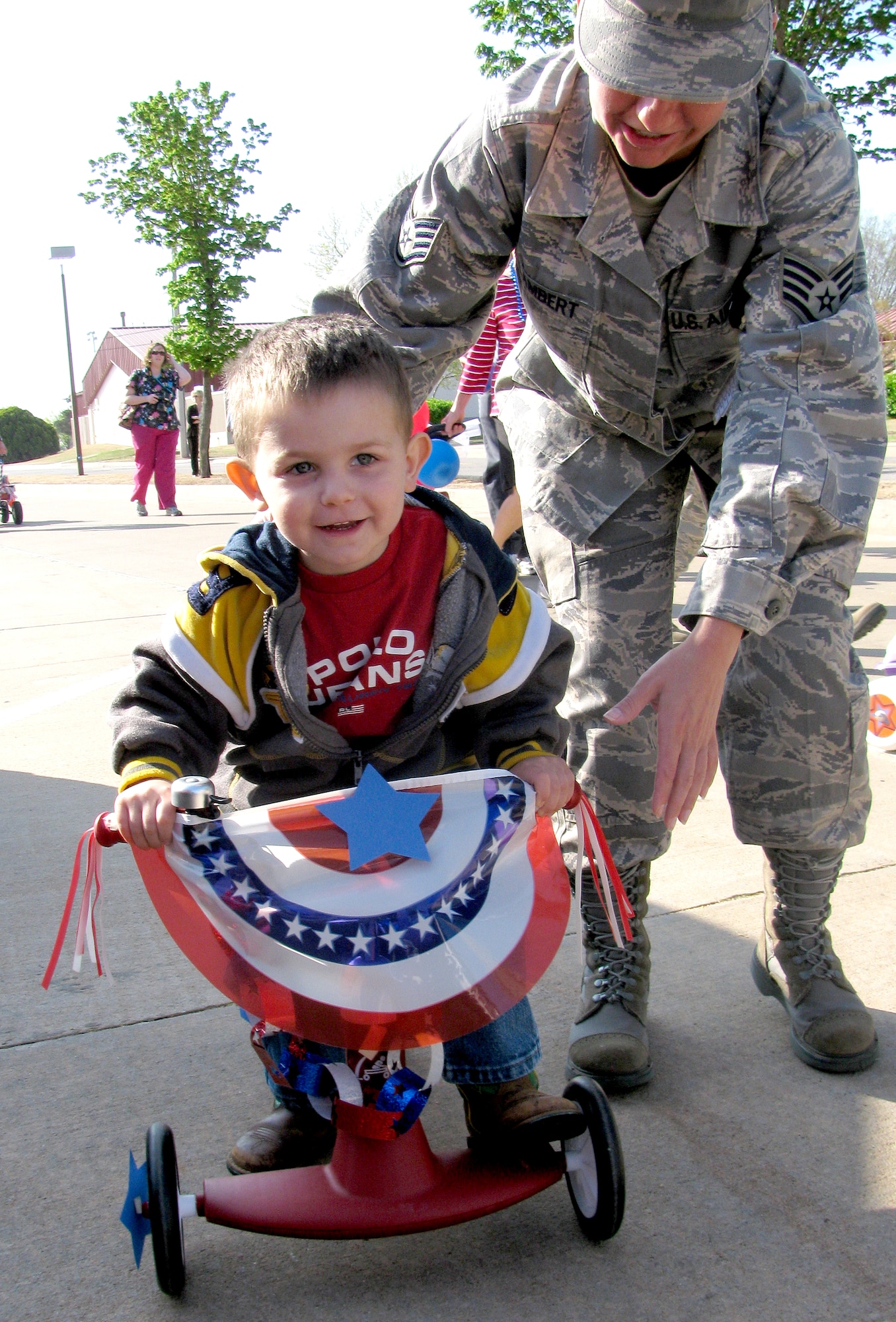 Cody Lambert and his mother, Staff Sgt. Mandy Lambert with the 71st Medical Group, participate in a military-child parade put on April 14 by the Child Development Center at Vance AFB, Okla. Almost 100 children, parents and CDC teachers marched in the parade, held in honor of the Month of the Military Child and the Week of the Young Child. (U.S. Air Force photo/ Jillian Moore)