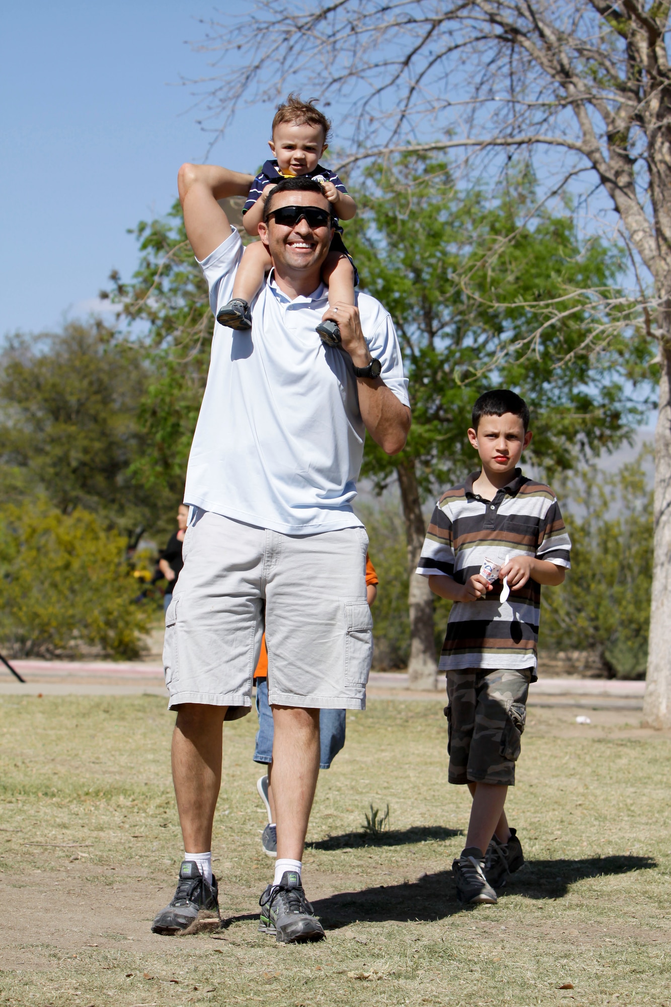 Maj. Fausto Padilla and his sons Lucas, 10, and Diego, 13 months, enjoy a walk through Udall Park during the 162nd Fighter Wing’s annual picnic April 11. (Air Force photo by Master Sgt. Hollie Hansen)