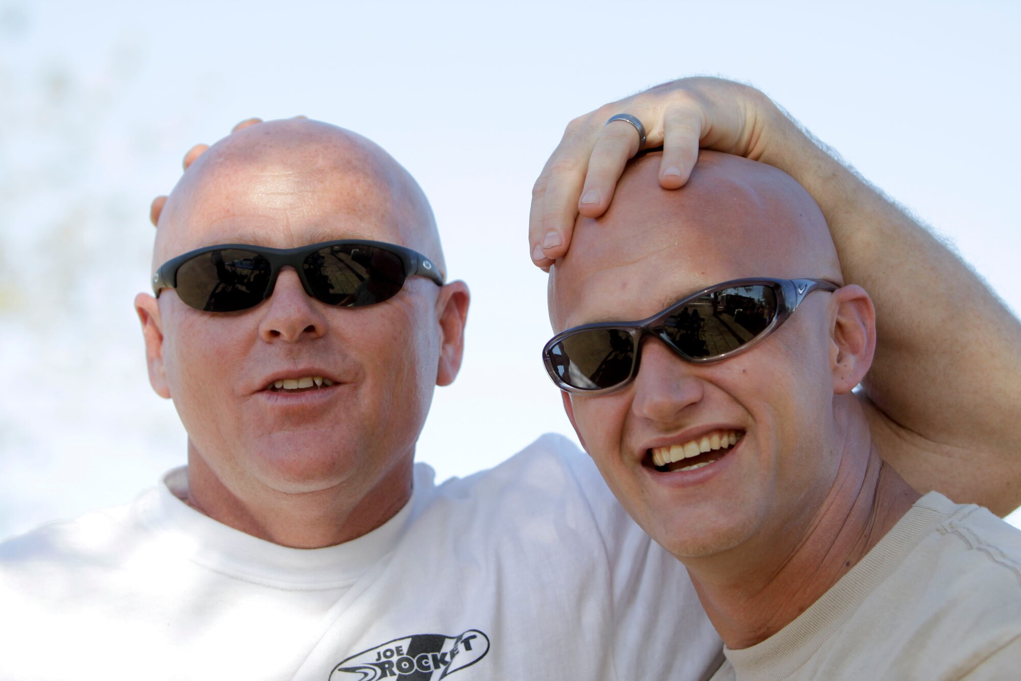 Master Sgt. Archie Burnett, left, and Jed Wells protect each other’s head from the Arizona sun at the 162nd Fighter Wing’s annual picnic April 11. (Air Force photo by Master Sgt. Hollie Hansen)