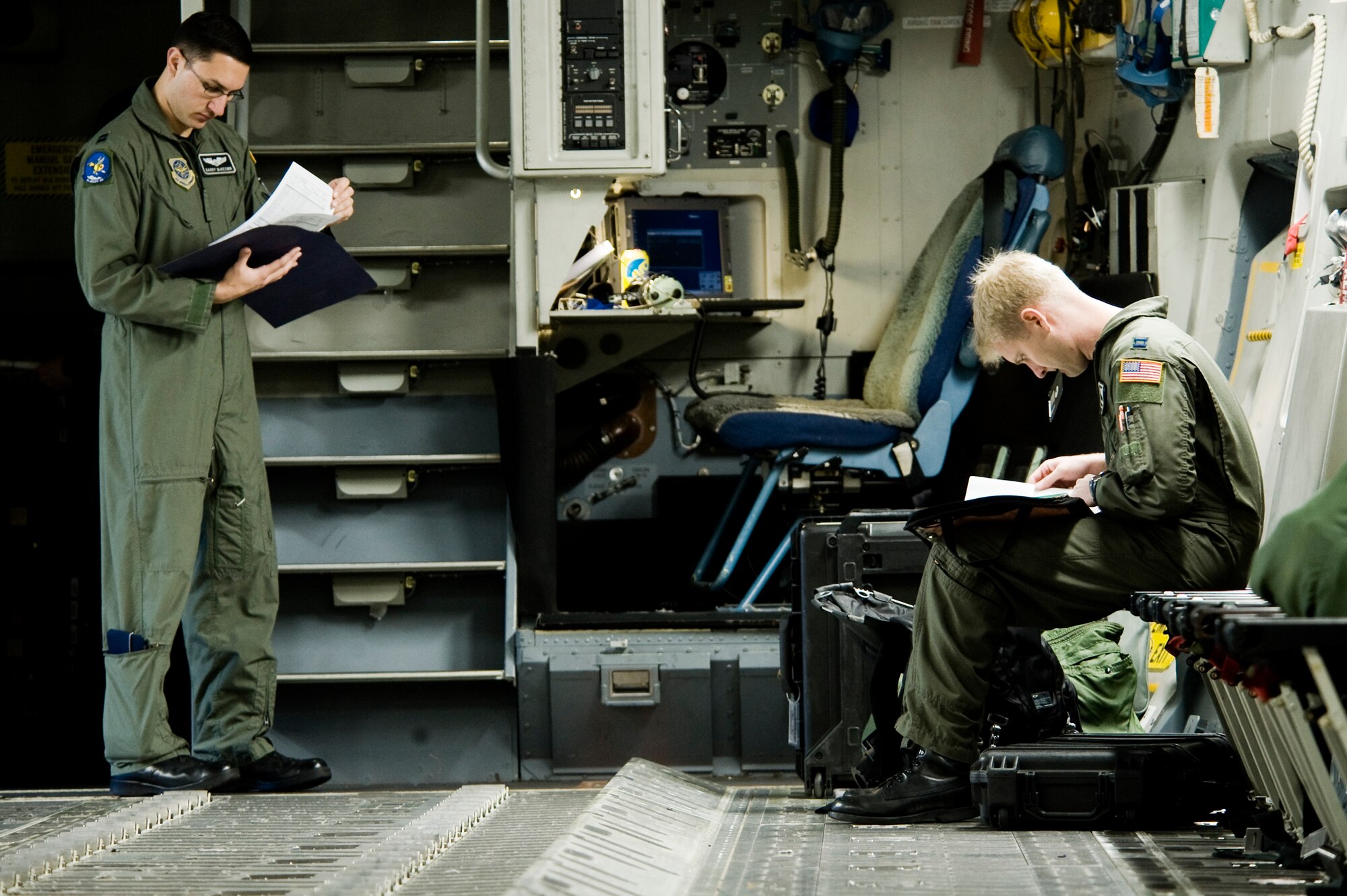 Capts. Barry McKeown and Tyler Creasman, 8th Airlift Squadron, review aircraft forms prior to departing on a training mission from McChord Field April 13.  In addition to preparing for an upcoming deployment to the Middle East, crews from the 8th AS have been maintaining a demanding operations tempo. (U.S. Air Force Photo by Abner Guzman)